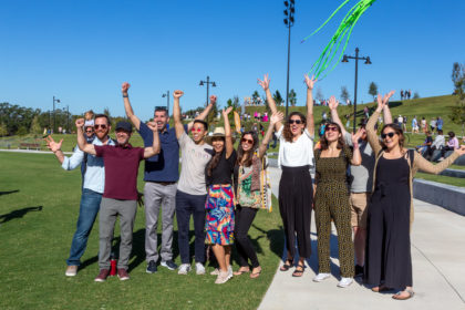 Group photo of design team smiling with their hands in the air at the opening of Bonnet Springs Park