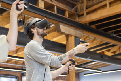 Photo of someone wearing VR goggles and holding remotes