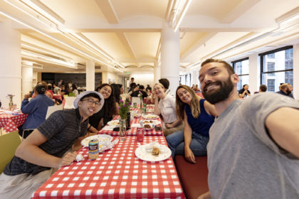 Selfie of a group of people at a table with a checkered tablecloth for the summer BBQ