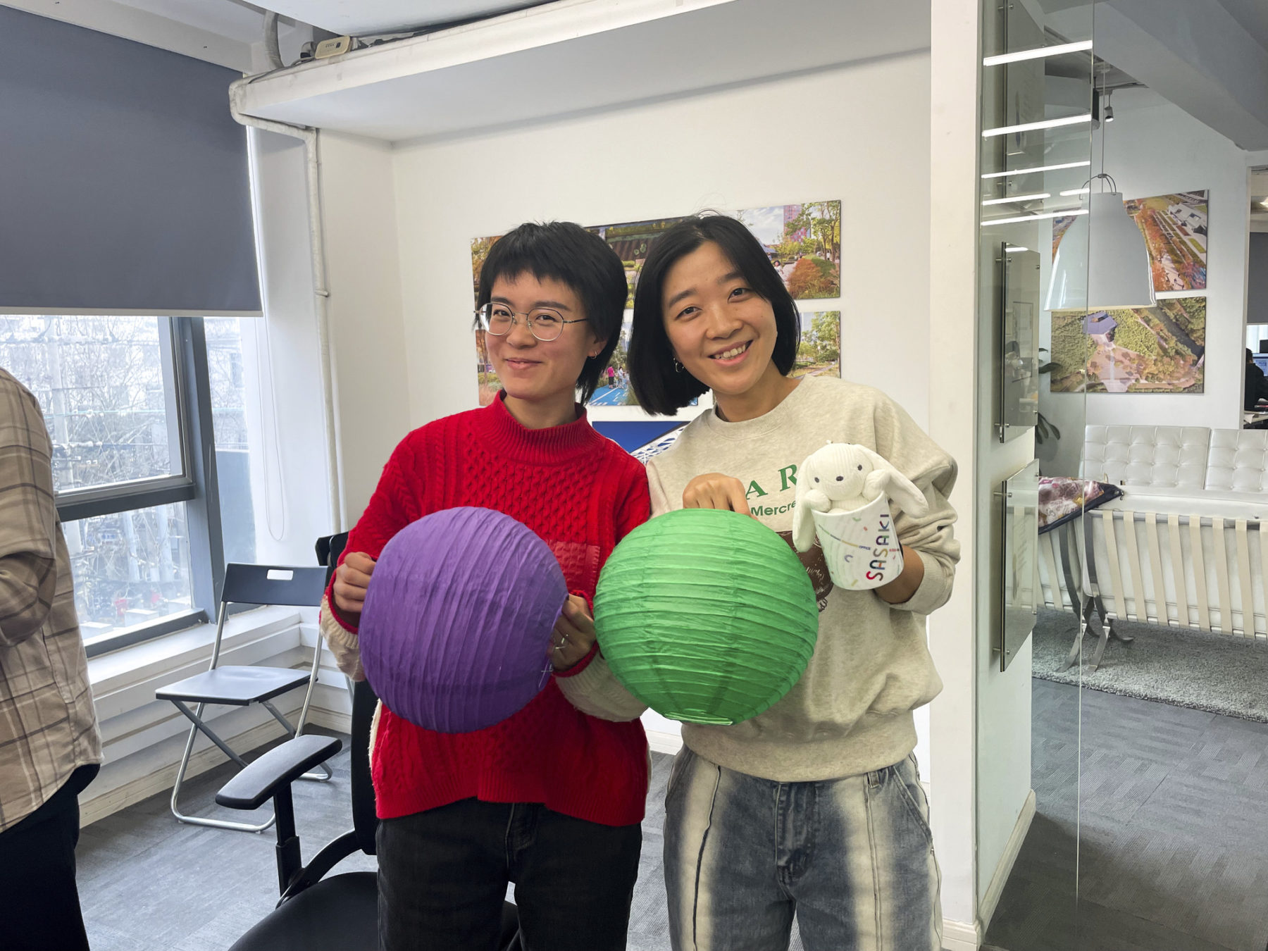 Image of two people smiling holding homemade paper lanterns