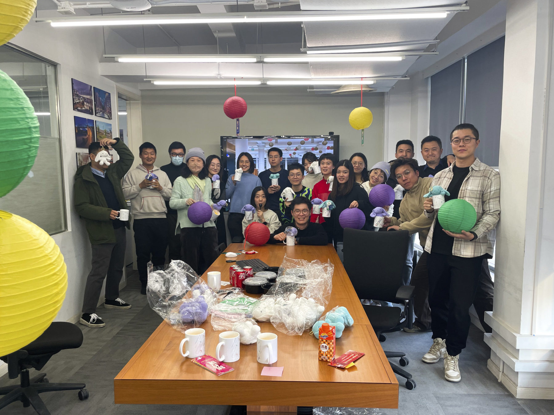 people smiling gathered in a conference room holding lanterns