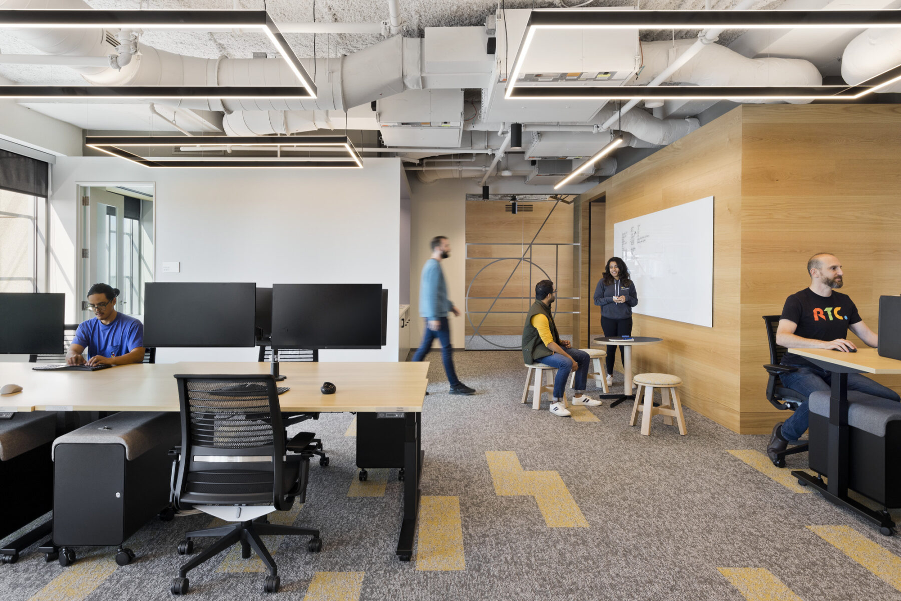 Dedicated team area with work station and wood clad wall in background