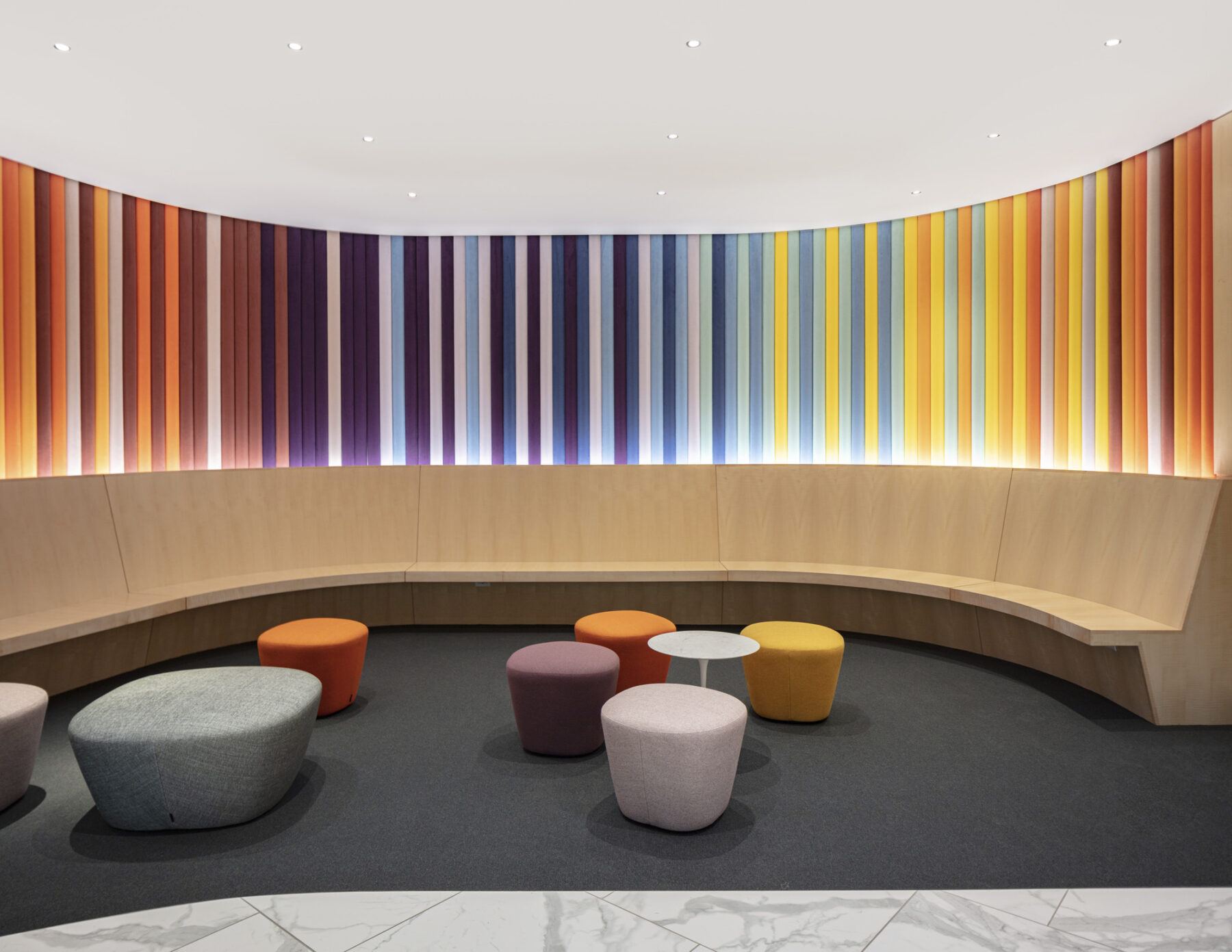 Lobby space with wrap around built-in bench and colorfully upholstered wall