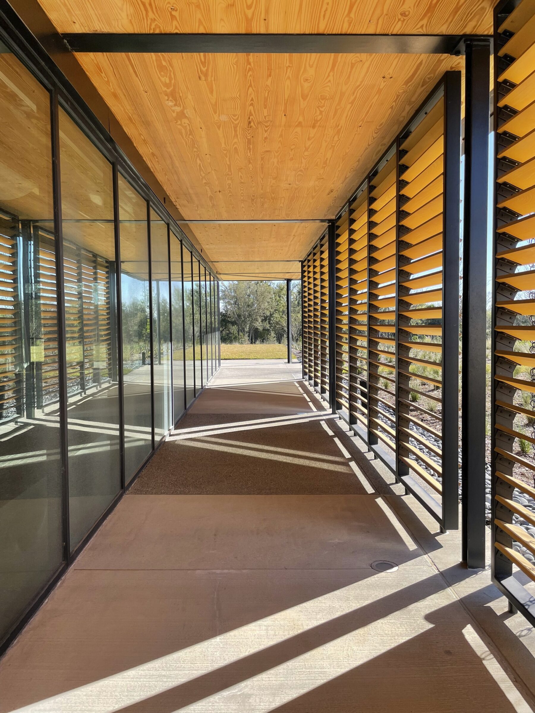 perspective image of path surrounding event center featuring overhangs and wooden screens