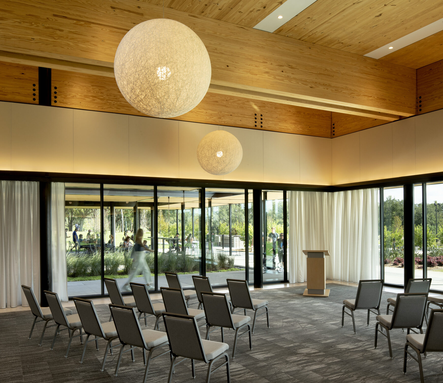 photograph of mian banquet hall of event center featuring globe light fixtures and exposed wood structures