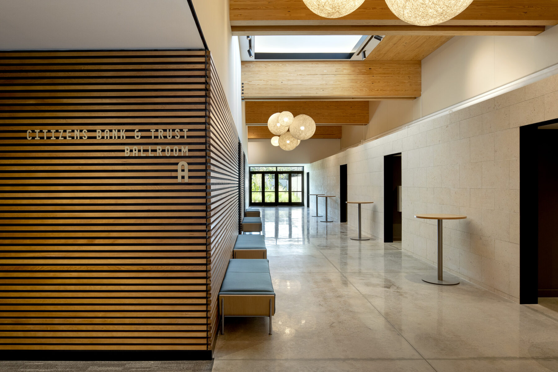 photograph of interior of event center, detailing the horizontal wood paneling and various skylights