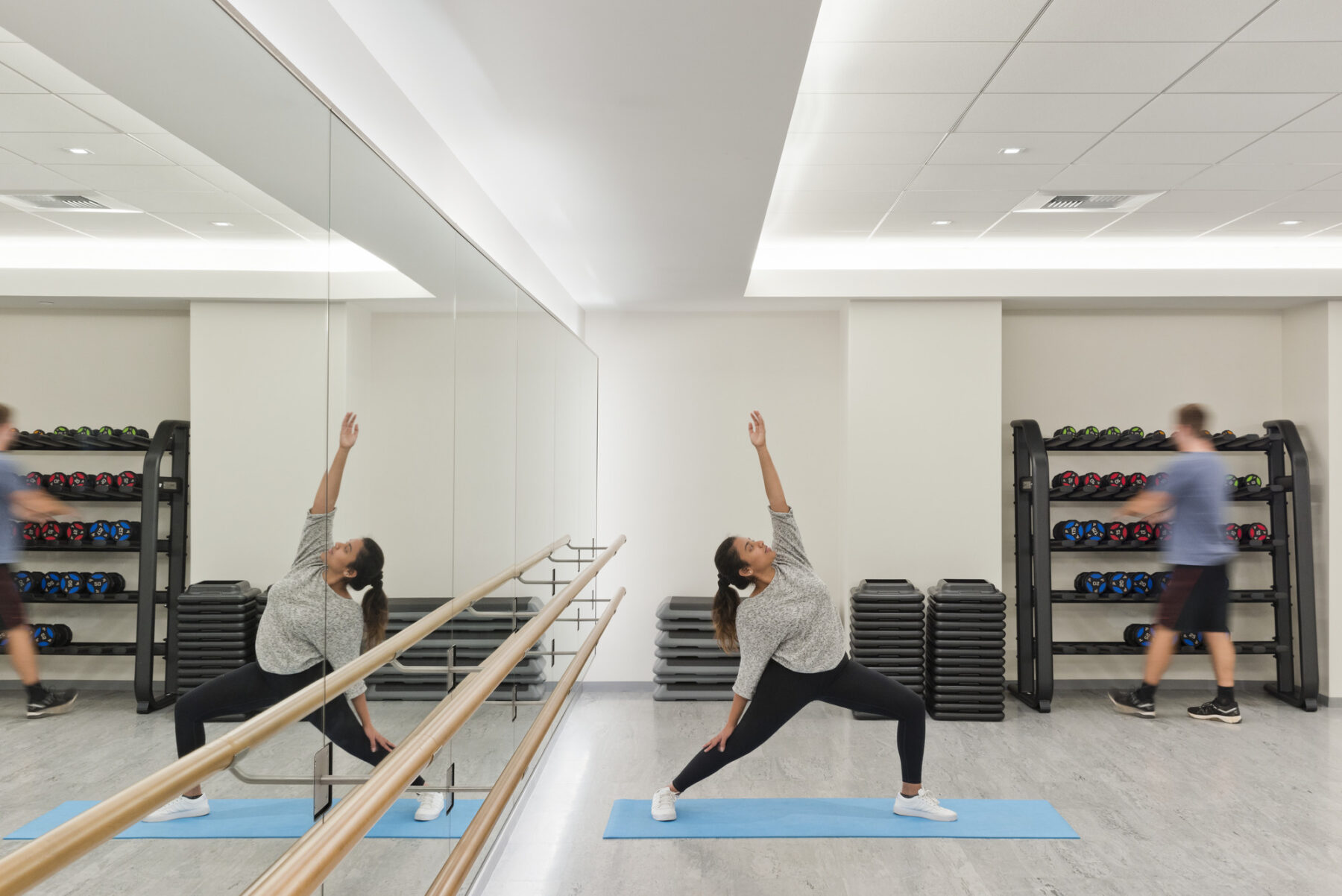 Open fitness and yoga studio with woman in pose standing on a yoga mat
