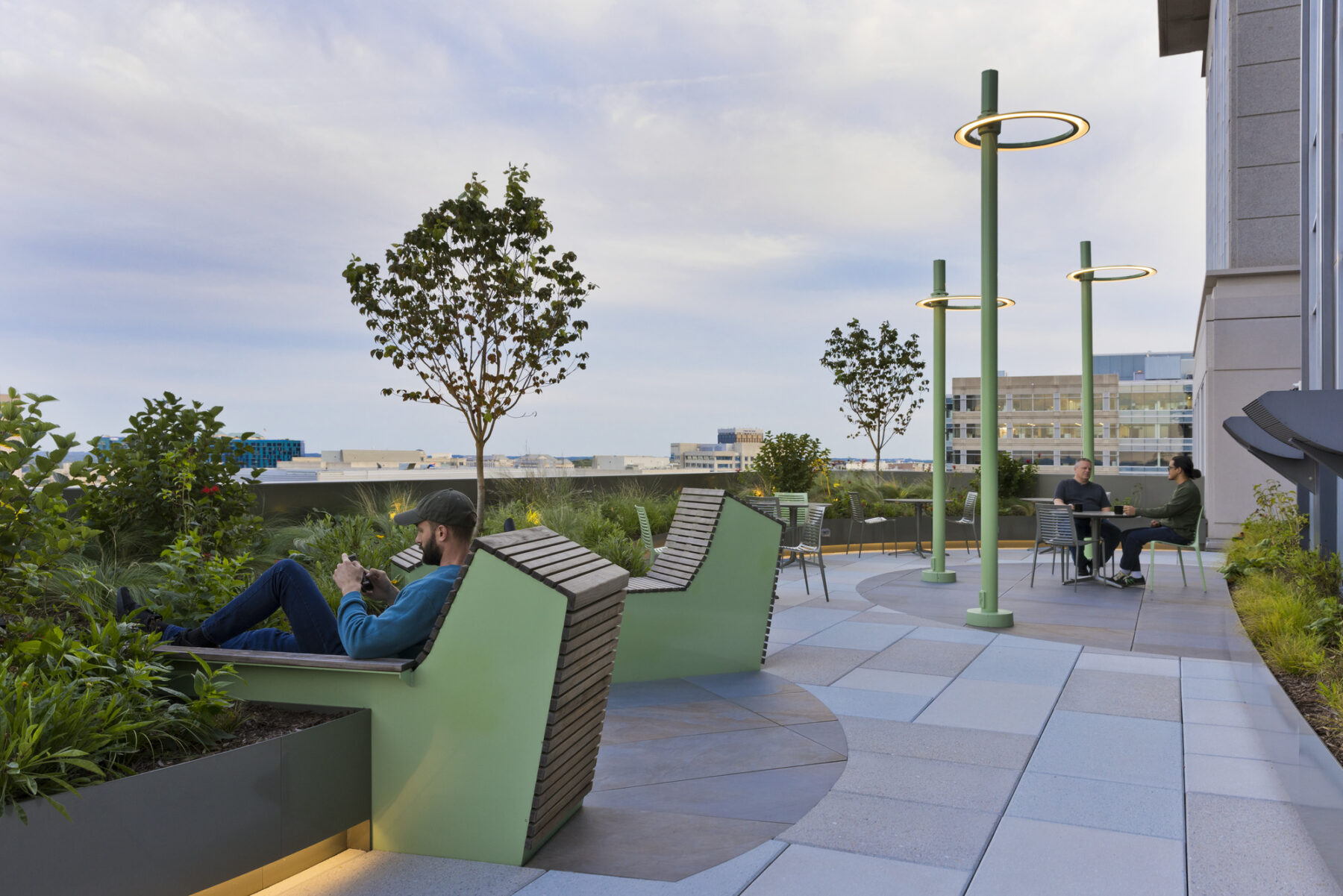 Roof terrace at dusk with custom reclining wooden benches and poles for hammocks
