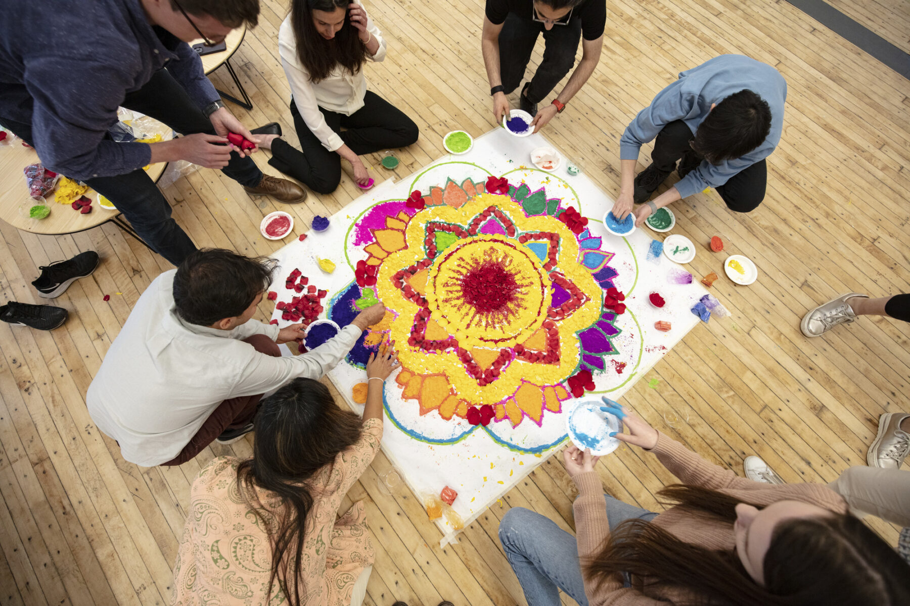 overhead photo of a group of people making rangoli