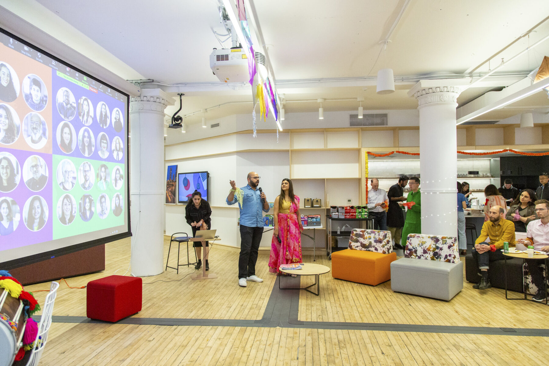 photo of two people giving a presentation in front of a large projector screen