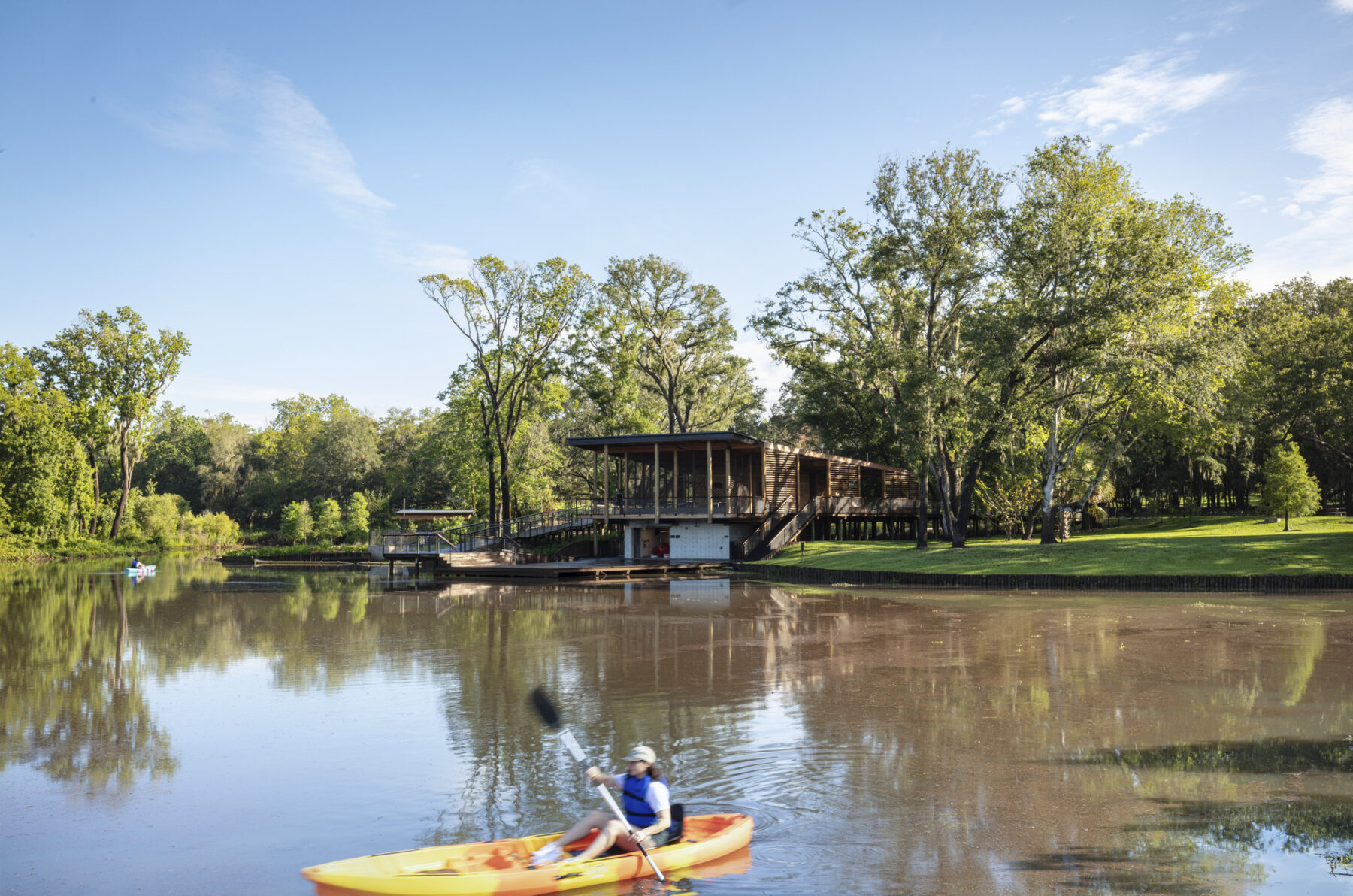 photograph of nature center boat house across from lagoon with kayak in water