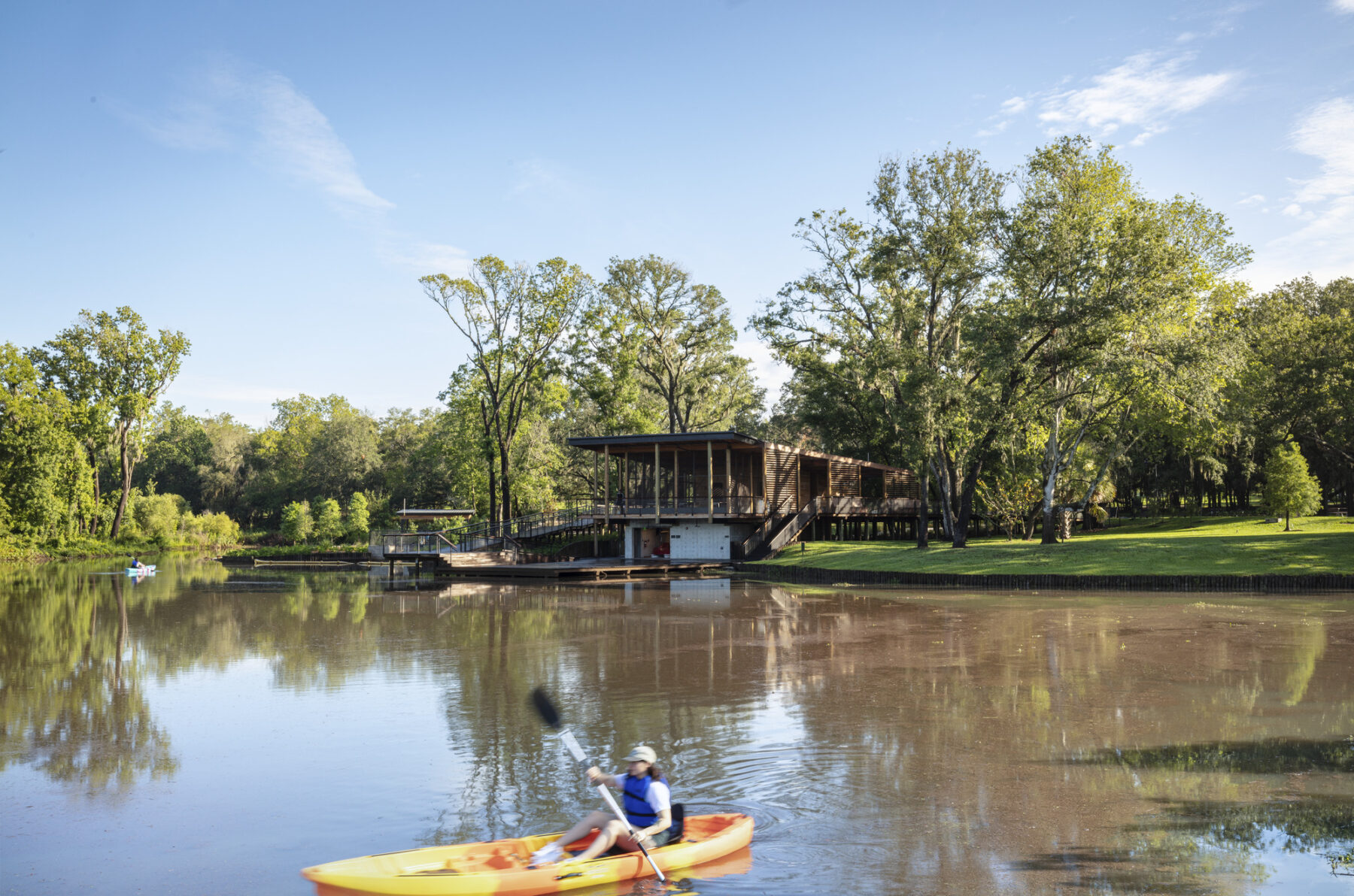 photograph of nature center boat house across from lagoon with kayak in water