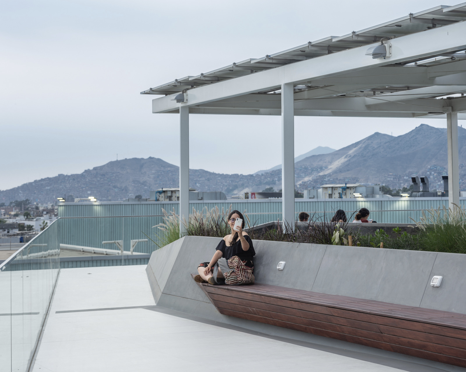 woman taking selfie on bench located on rooftop terrace