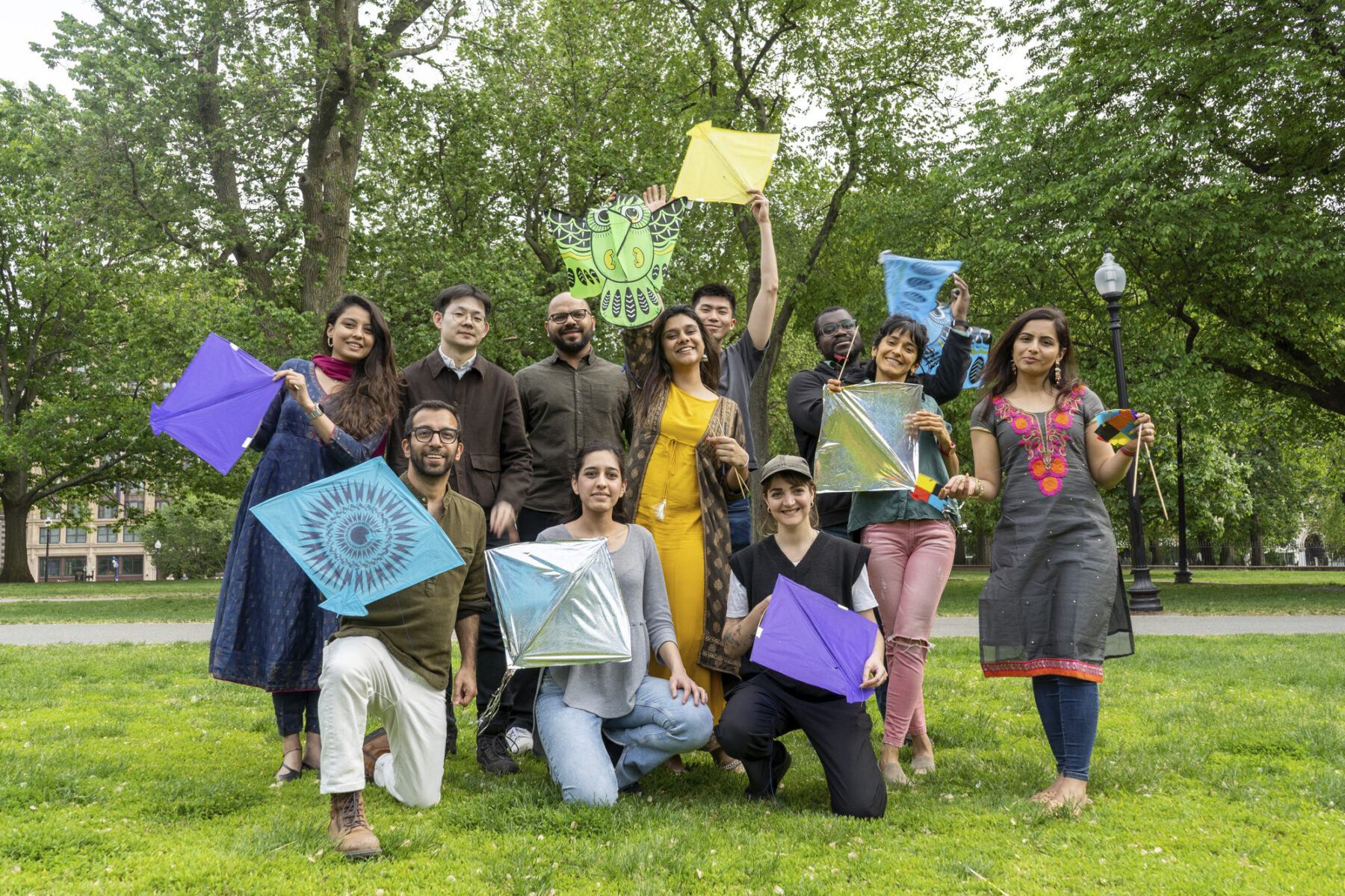 photo of a group of people holding up kites outside