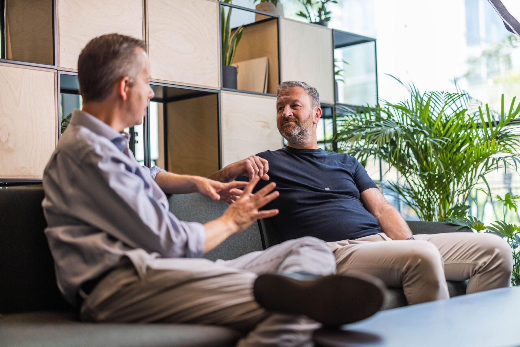 Two men in conversation sitting on a couch