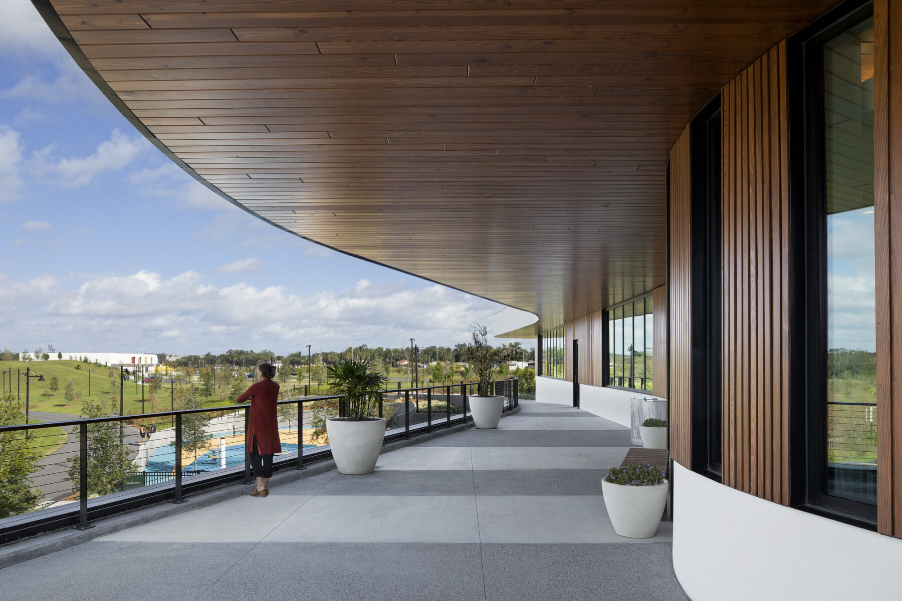 photograph of woman resting on balcony railing on the second floor patio of welcome center