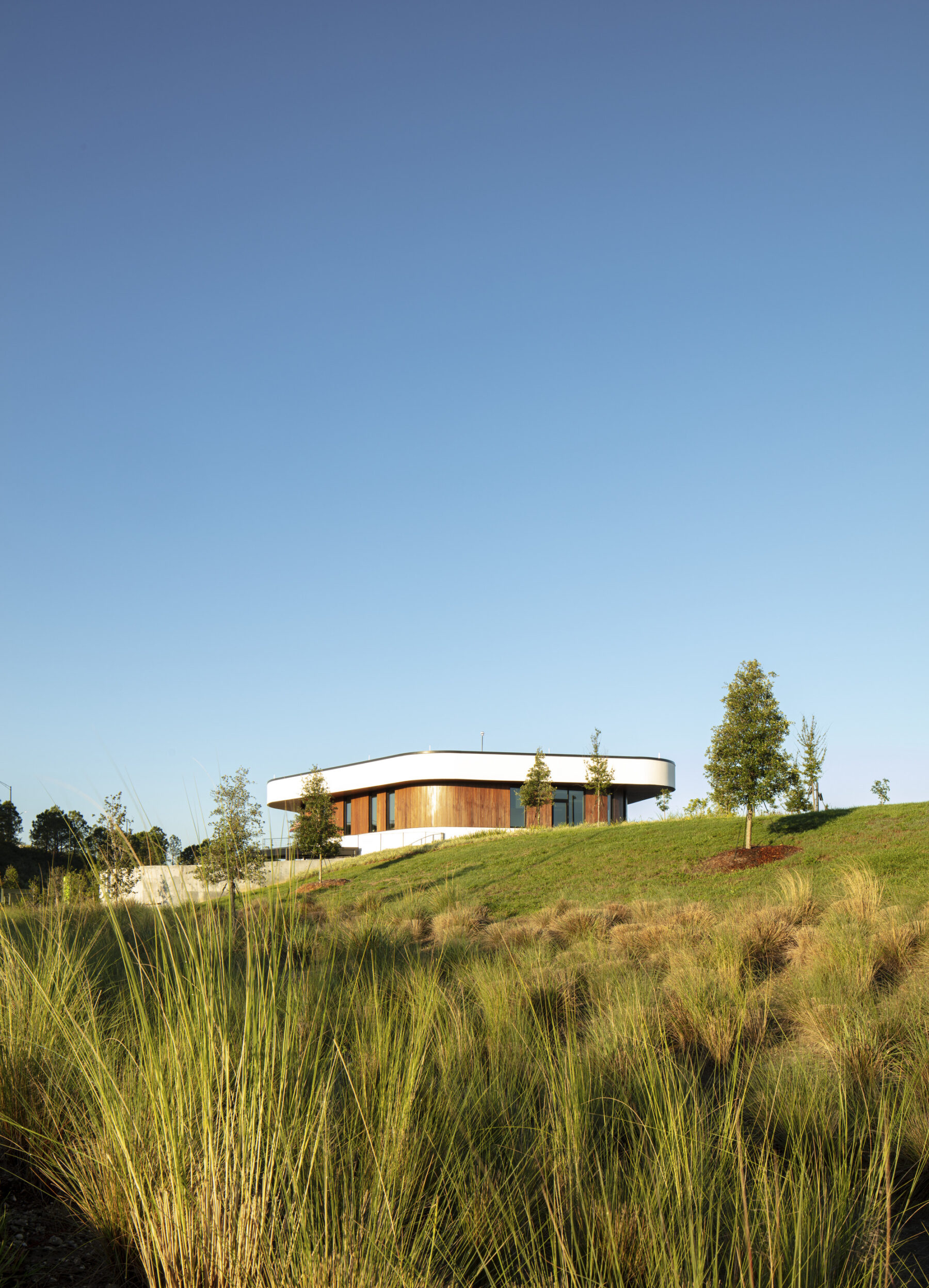 photograph of exterior of welcome center perched on top of hill with grass in foreground