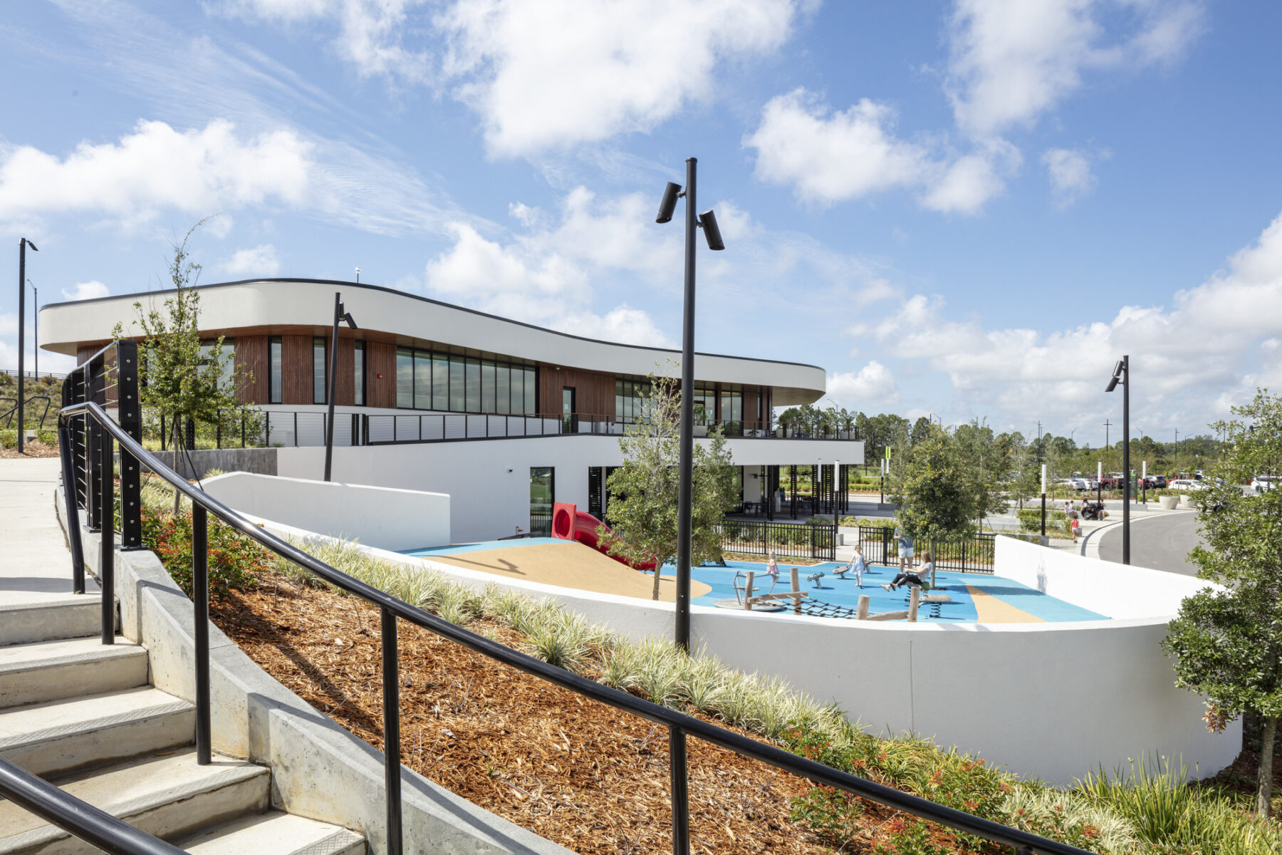 photograph of welcome center taken from curved staircase around playground that leads to second level patio