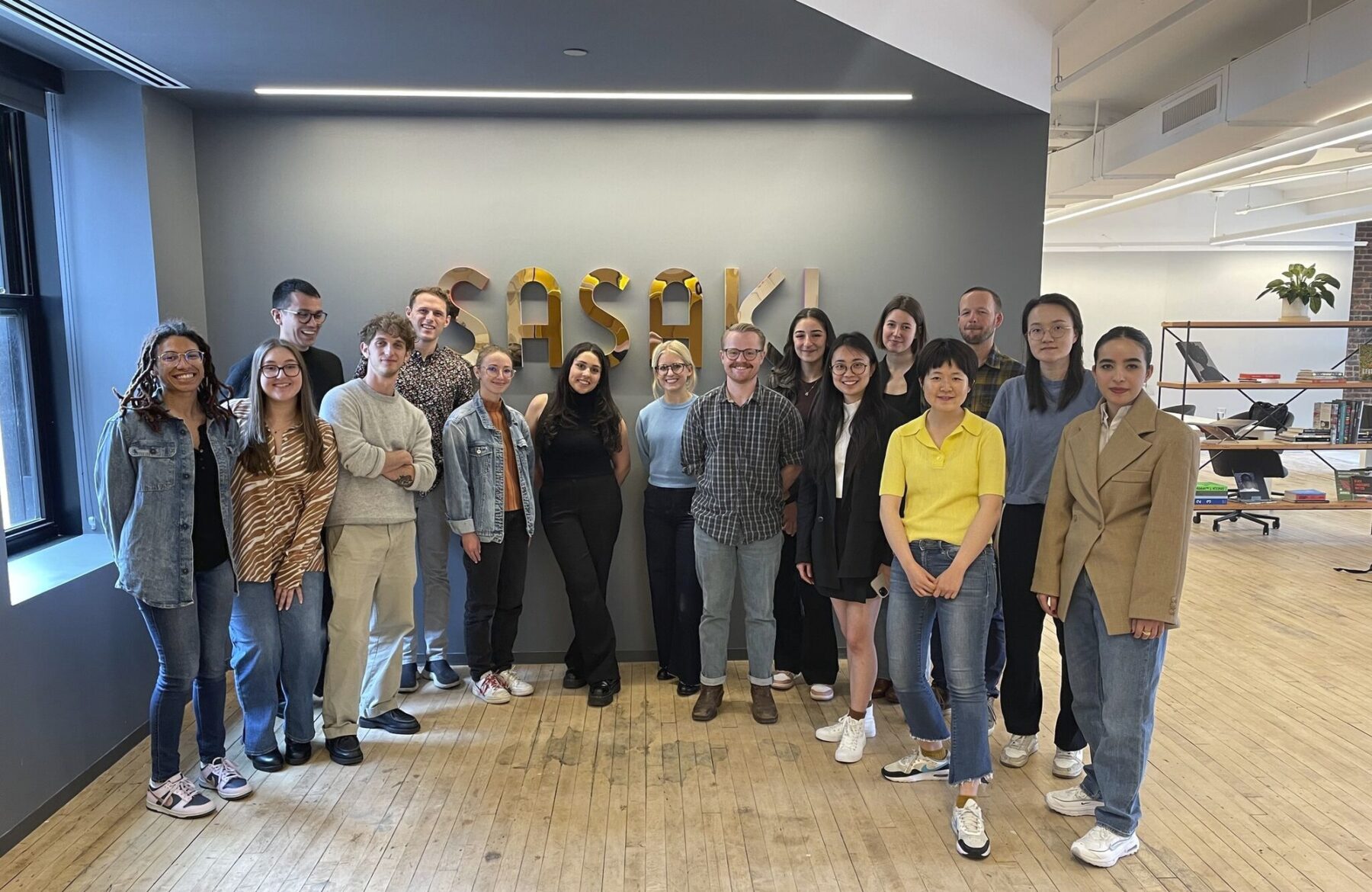 Group picture of the 2023 intern class in front of a Sasaki sign.