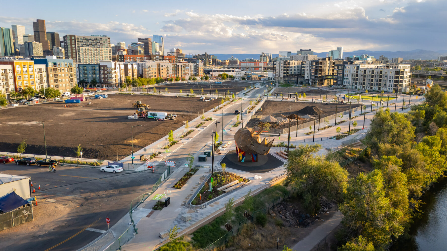 Aerial photo facing down the corridor of new streets lined with trees, planting, and public amenities like the iconic rhino climbing structure