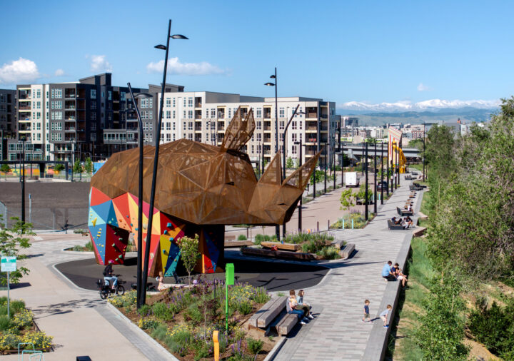 Aerial view of rhino and riverfront promenade with people sitting along the edge