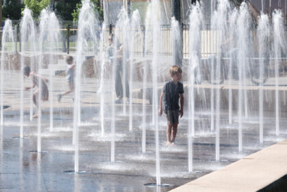 View of child playing in water fountain