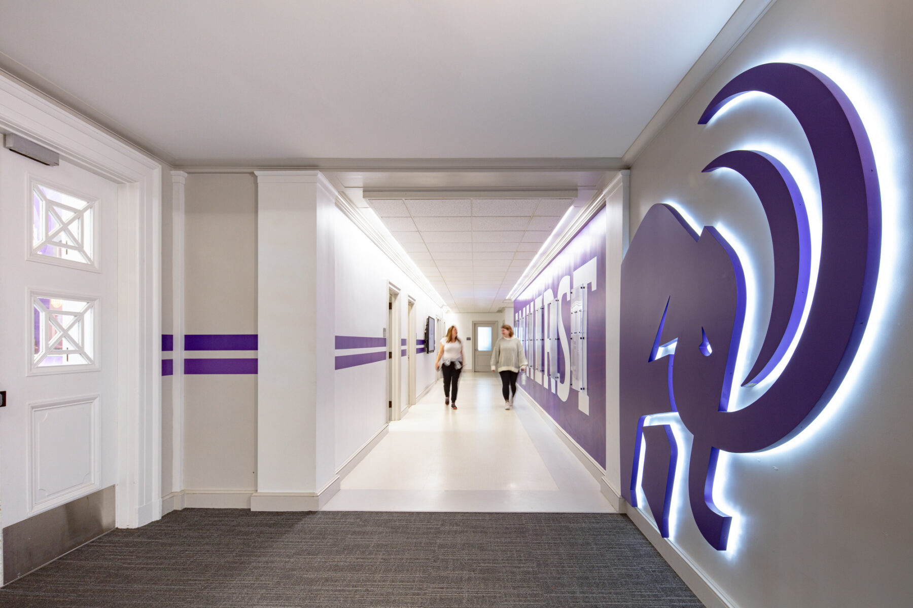 photograph of students walking down hallway with custom graphics featured on walls