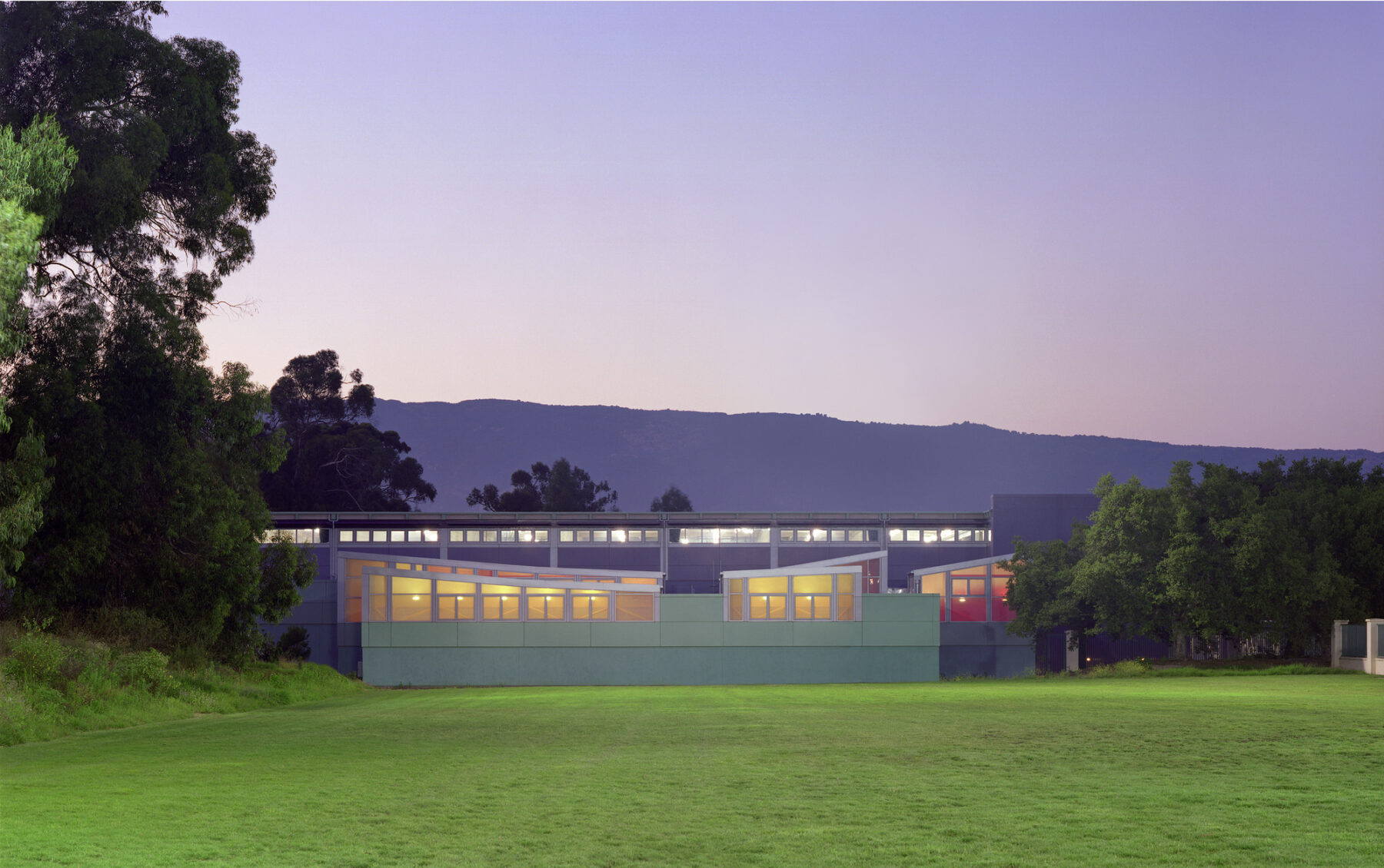 color photo of UCSB rec center, exterior, against a mountainous horizon