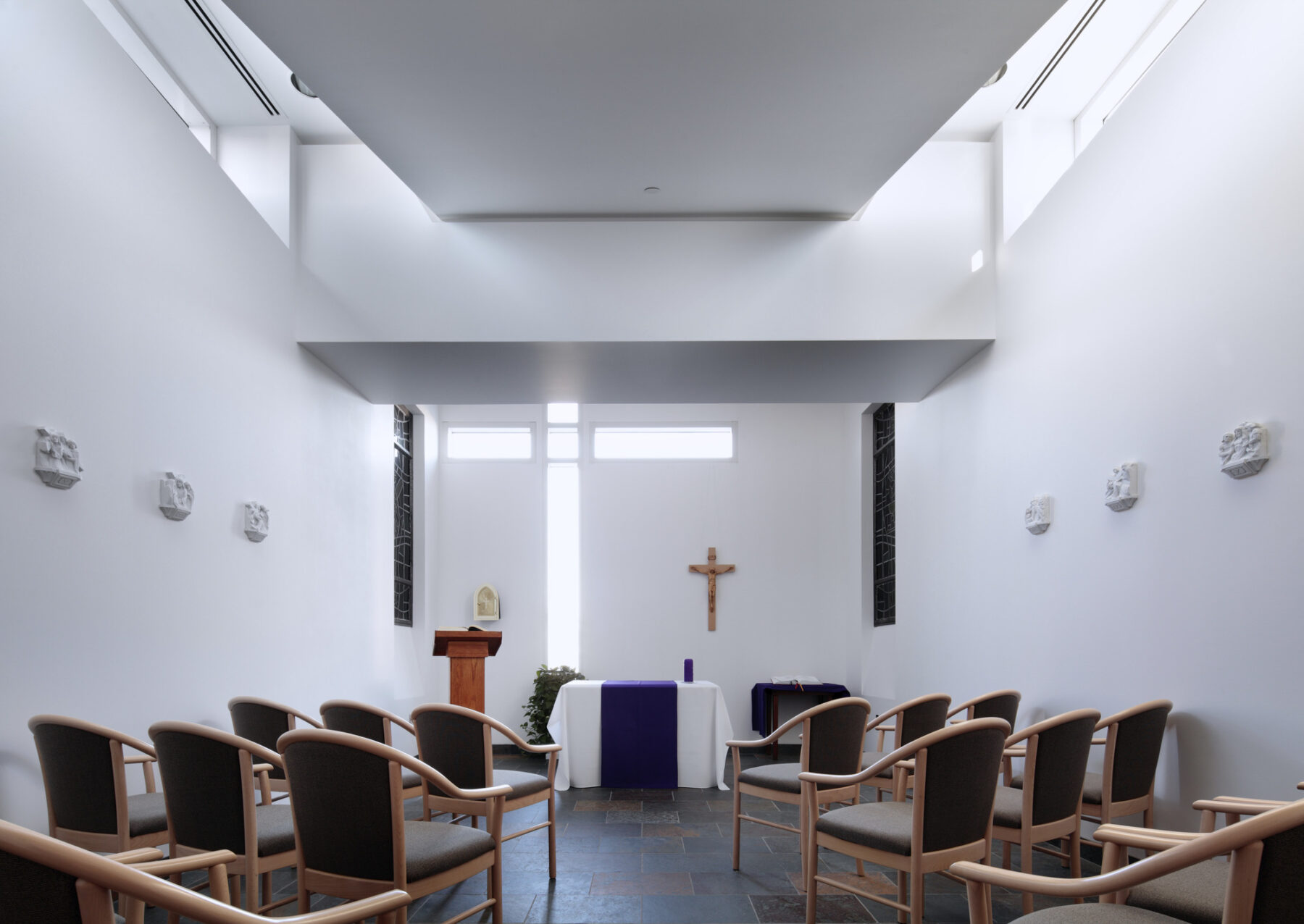 color photo of a small white chapel, lit by clerestory windows