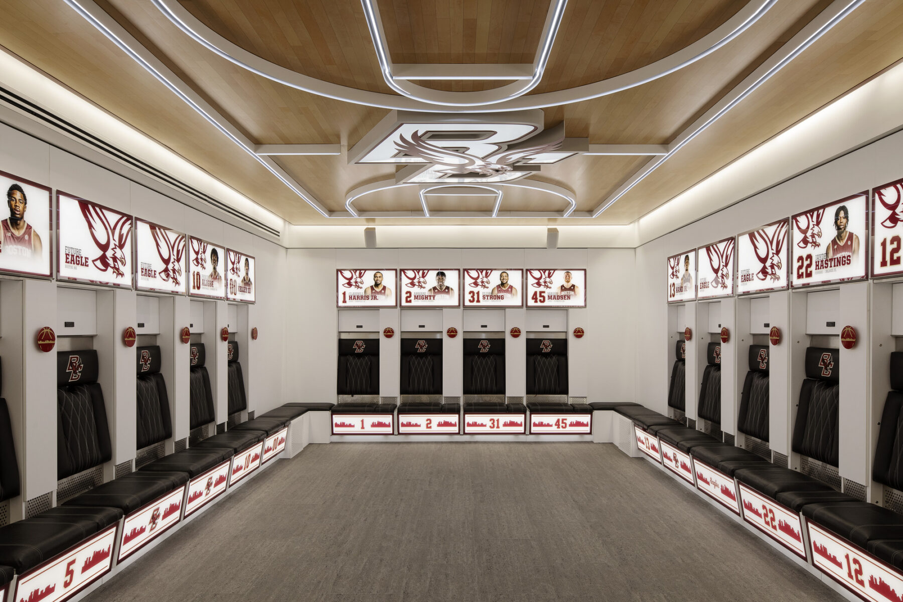 photo of locker room with illuminated player photos and design of basketball court and BC logo on the ceiling