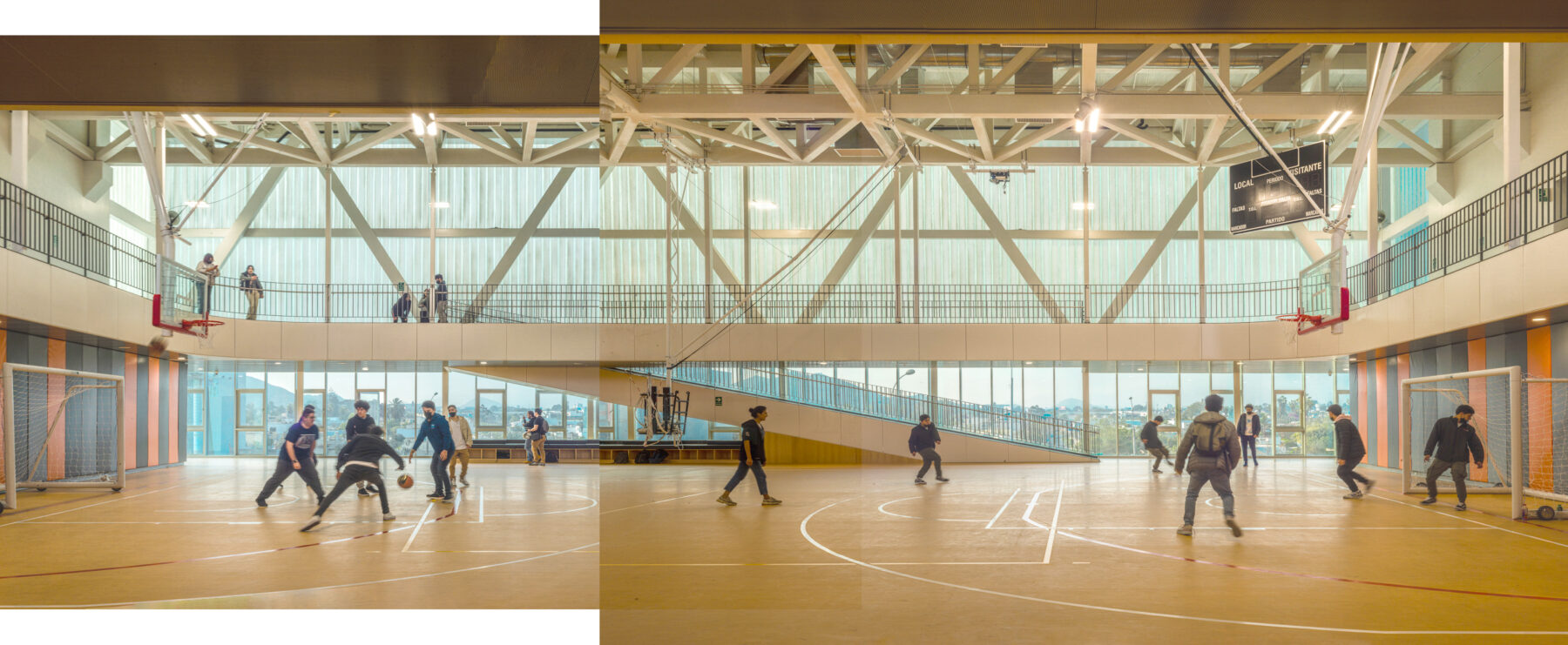 2 color photos stitched together to show a panorama of activity. Students play a game of futsol in the foreground. In the background the luminous facade yields a view of the city.