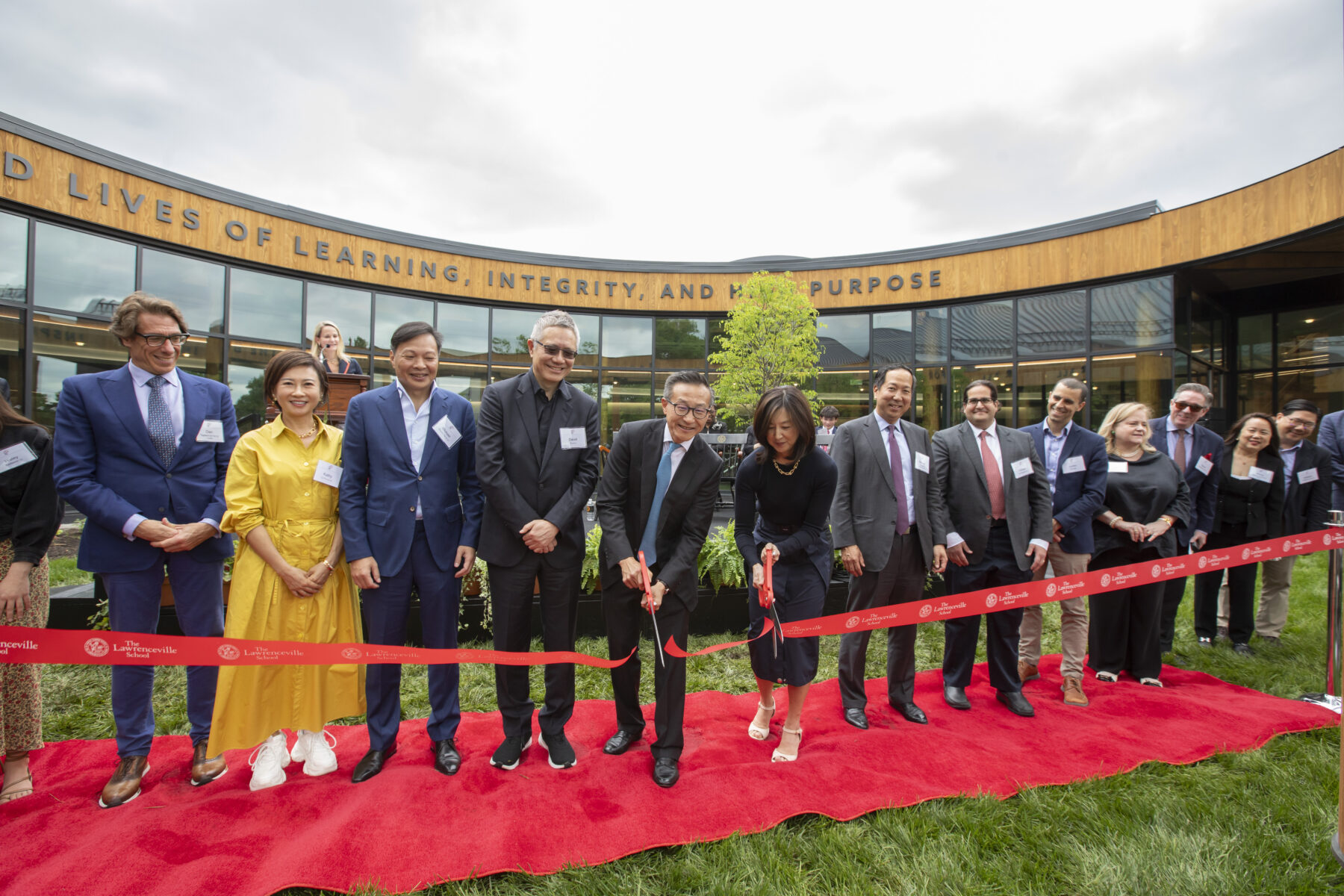 Joseph Tsai and Clara Wu cut the ribbon to phase two of the Tsai Commons and Field House in the building's oval-shaped courtyard, with several other guests beside them