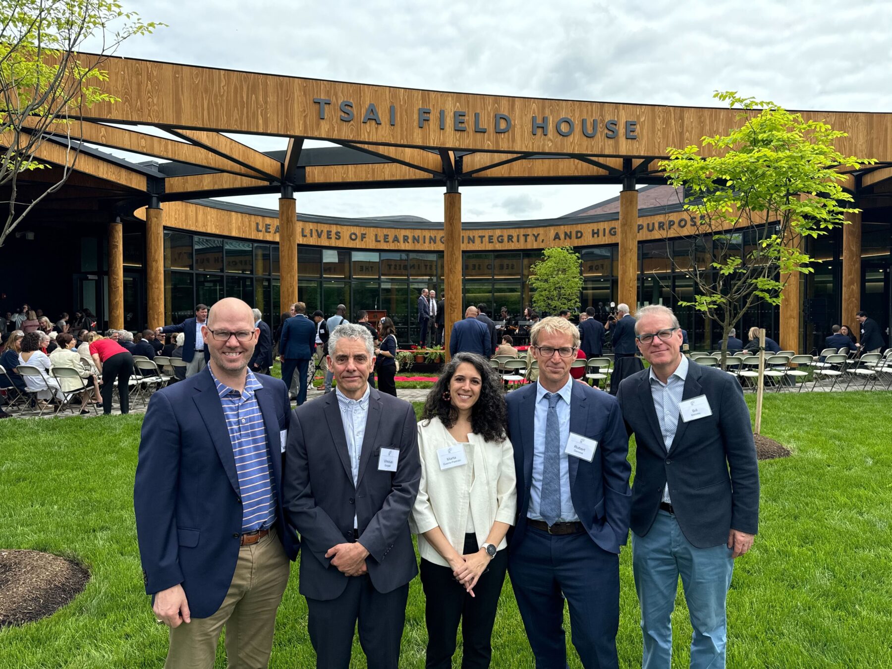 Design team Trey Sasser, Vinicius Gorgati, Marta Guerra-Pastrián, Robert Genova, and Bill Massey pose for a picture in front of the Tsai Commons and Field House courtyard at the building's grand opening ceremony
