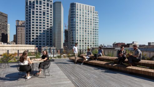 photograph of staff relazing on benches in roof deck
