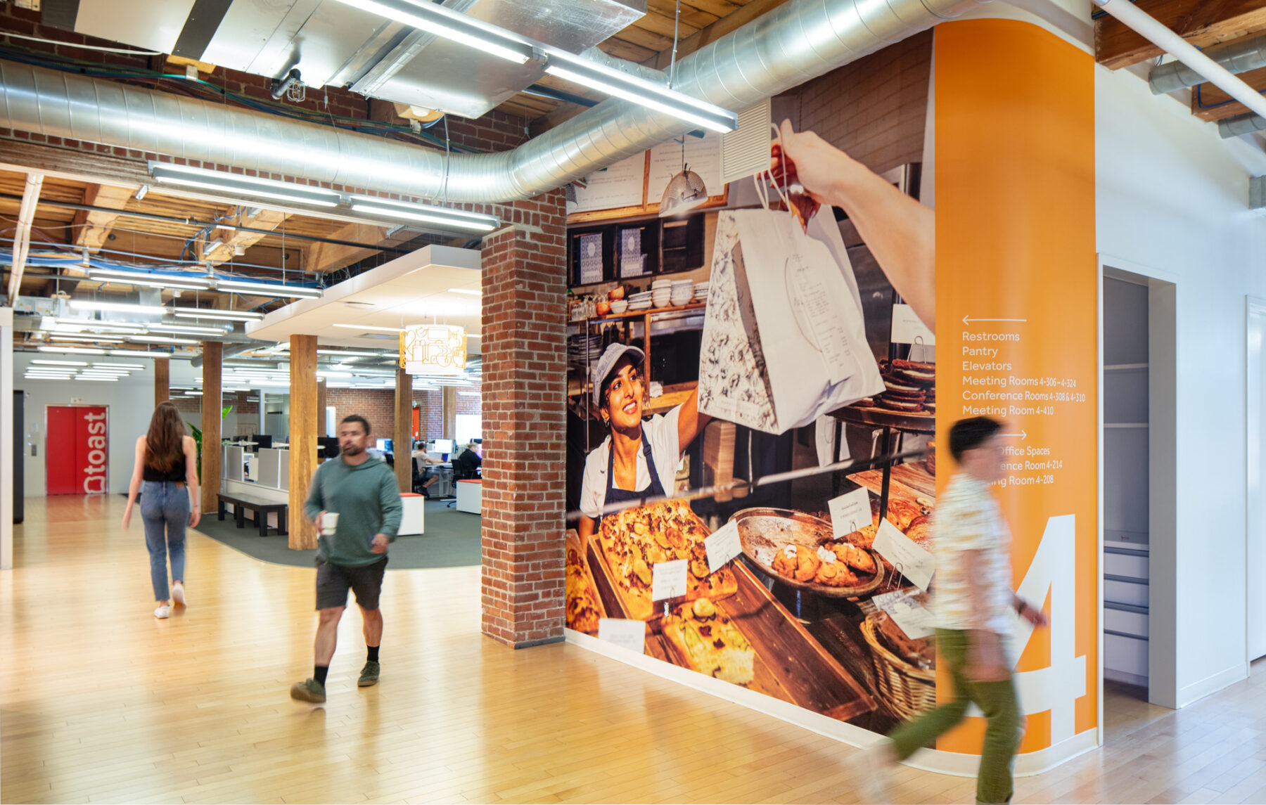 photograph of employees walking past bold graphics wall designed by Sasaki
