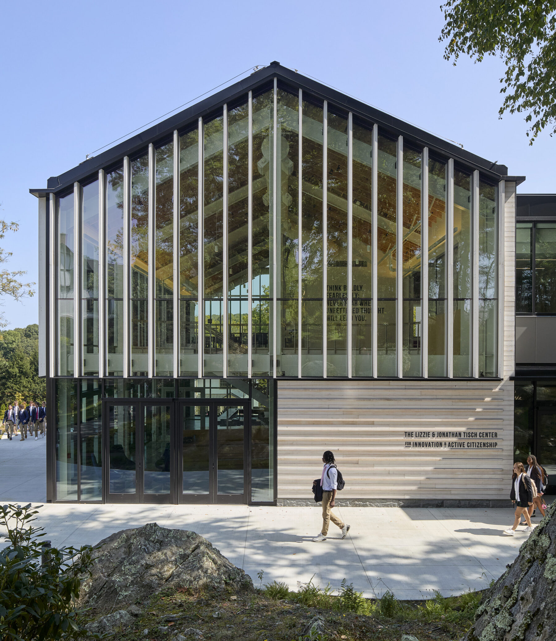 Photo of building exterior with elevational view of the main northern pavilion with the main entry and transparent curtain wall into the living room
