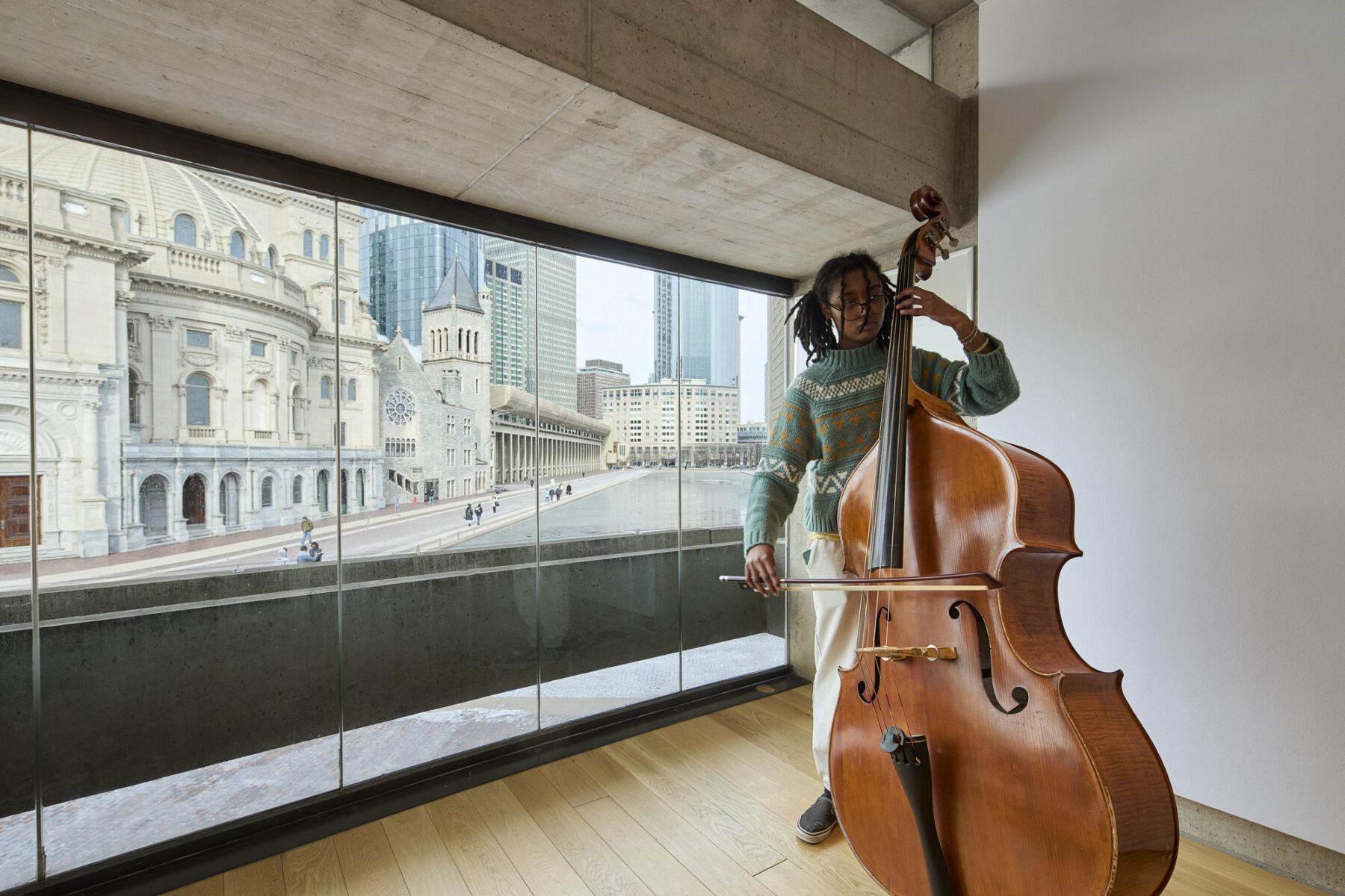 Student playing an upright bass in a practice room