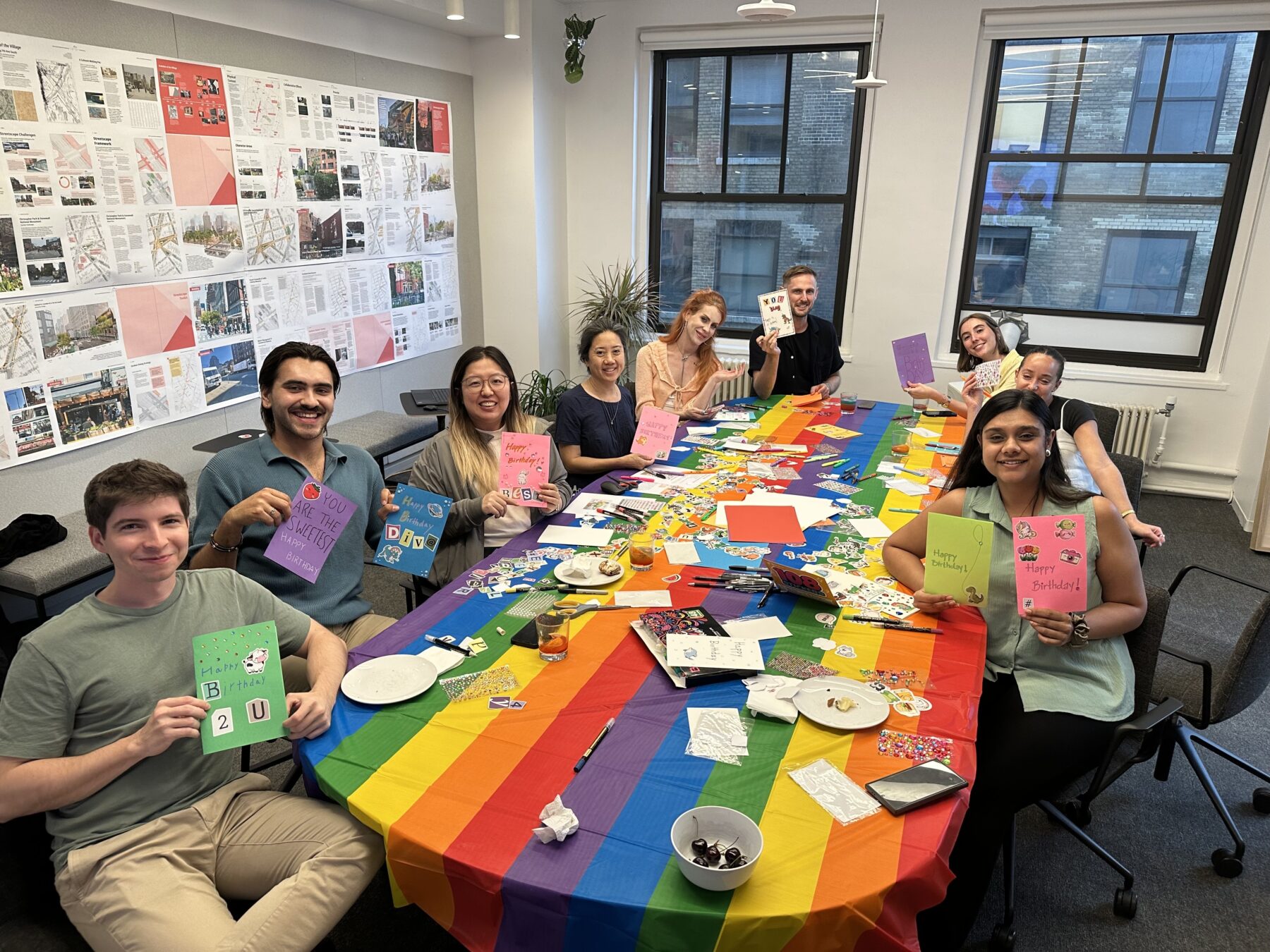 Group of people in a conference room covered in rainbows, working on Pride-theme crafts