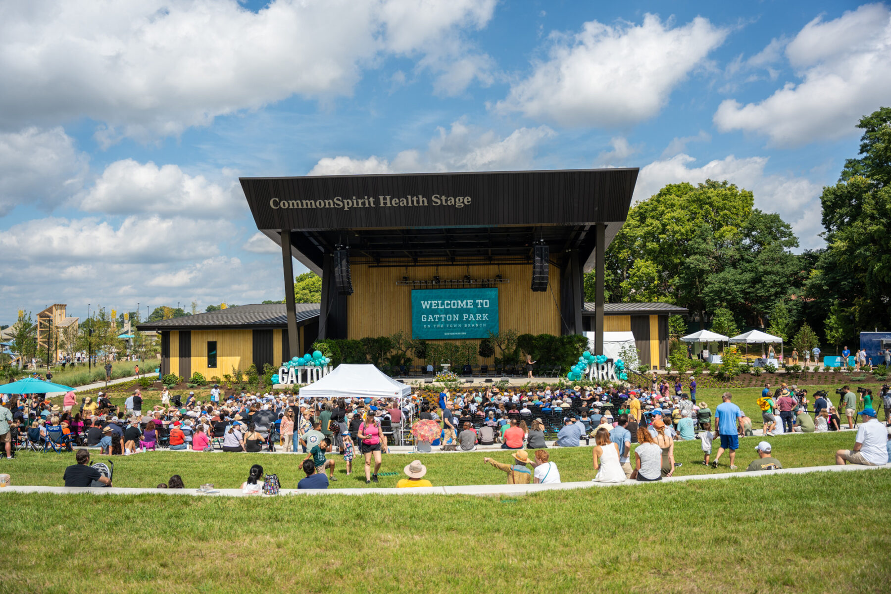 photo from the great lawn looking towards the new stage with an audience gathered around