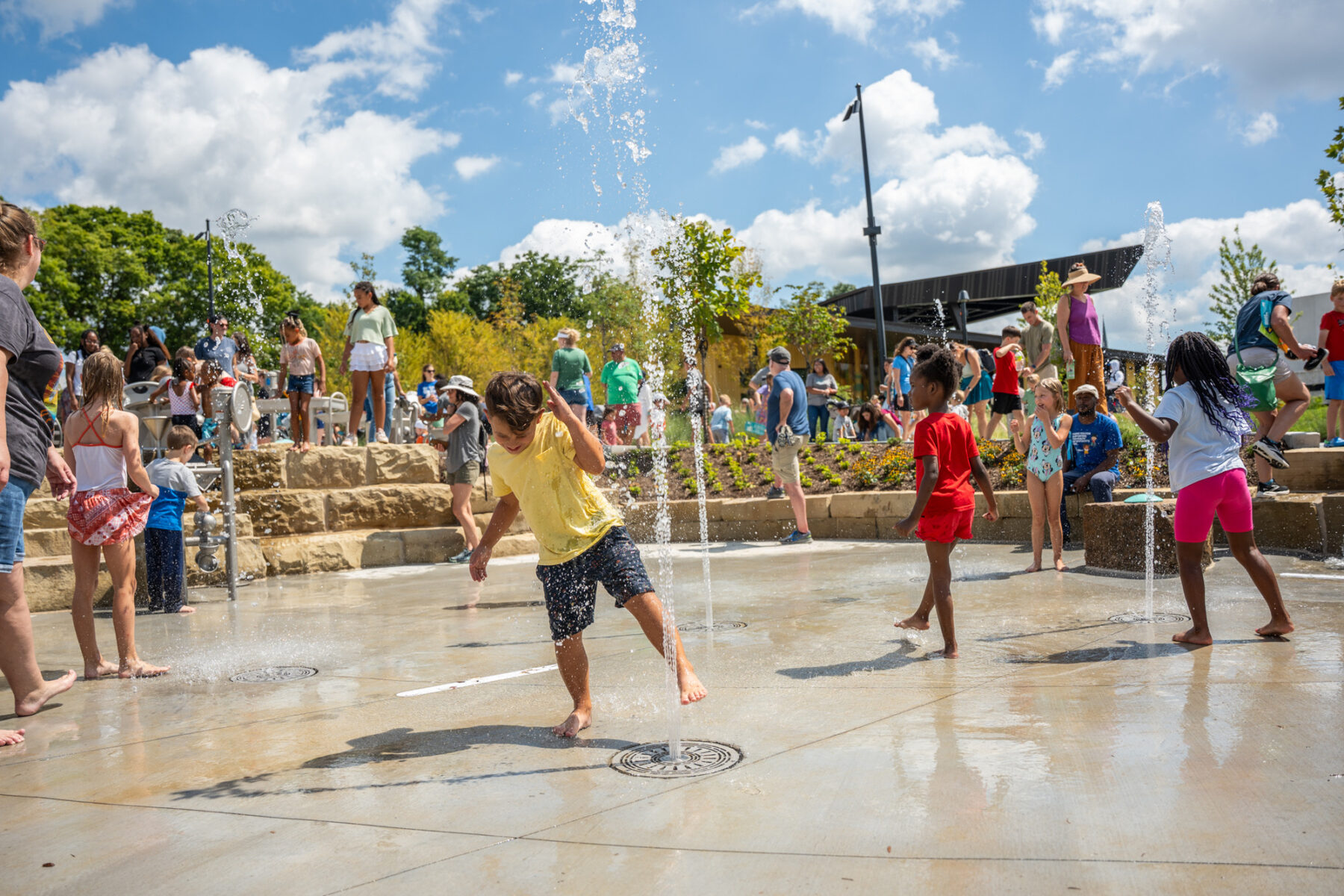 photo of water spout feature with children playing in the water
