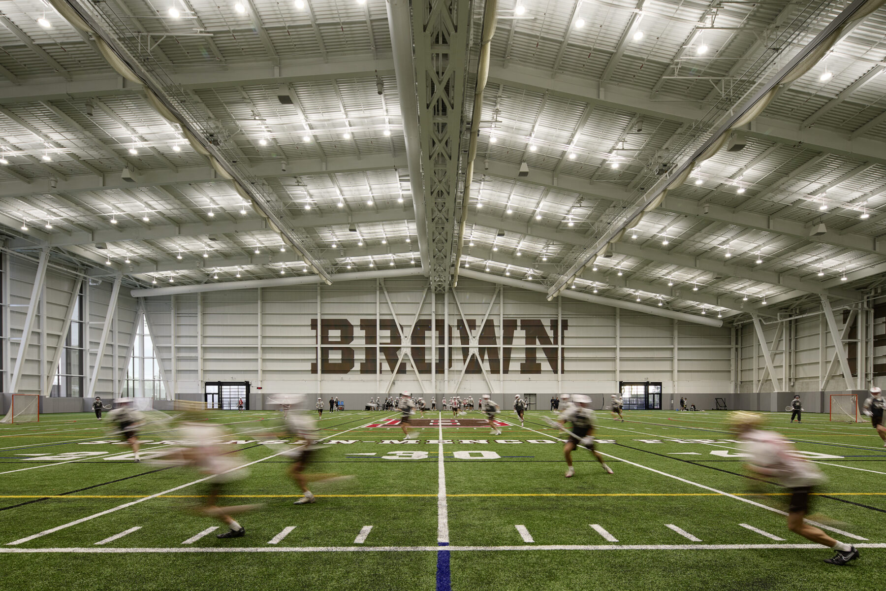 Photo of fieldhouse indoor turf field with men's lacrosse team practicing