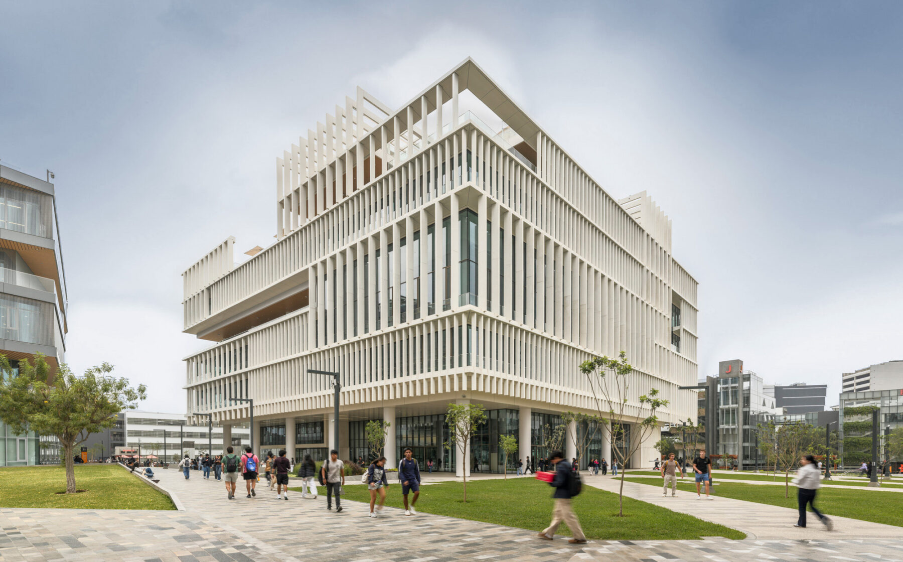 View of building corner emphasizing the screen facade system with students walking by in the foreground