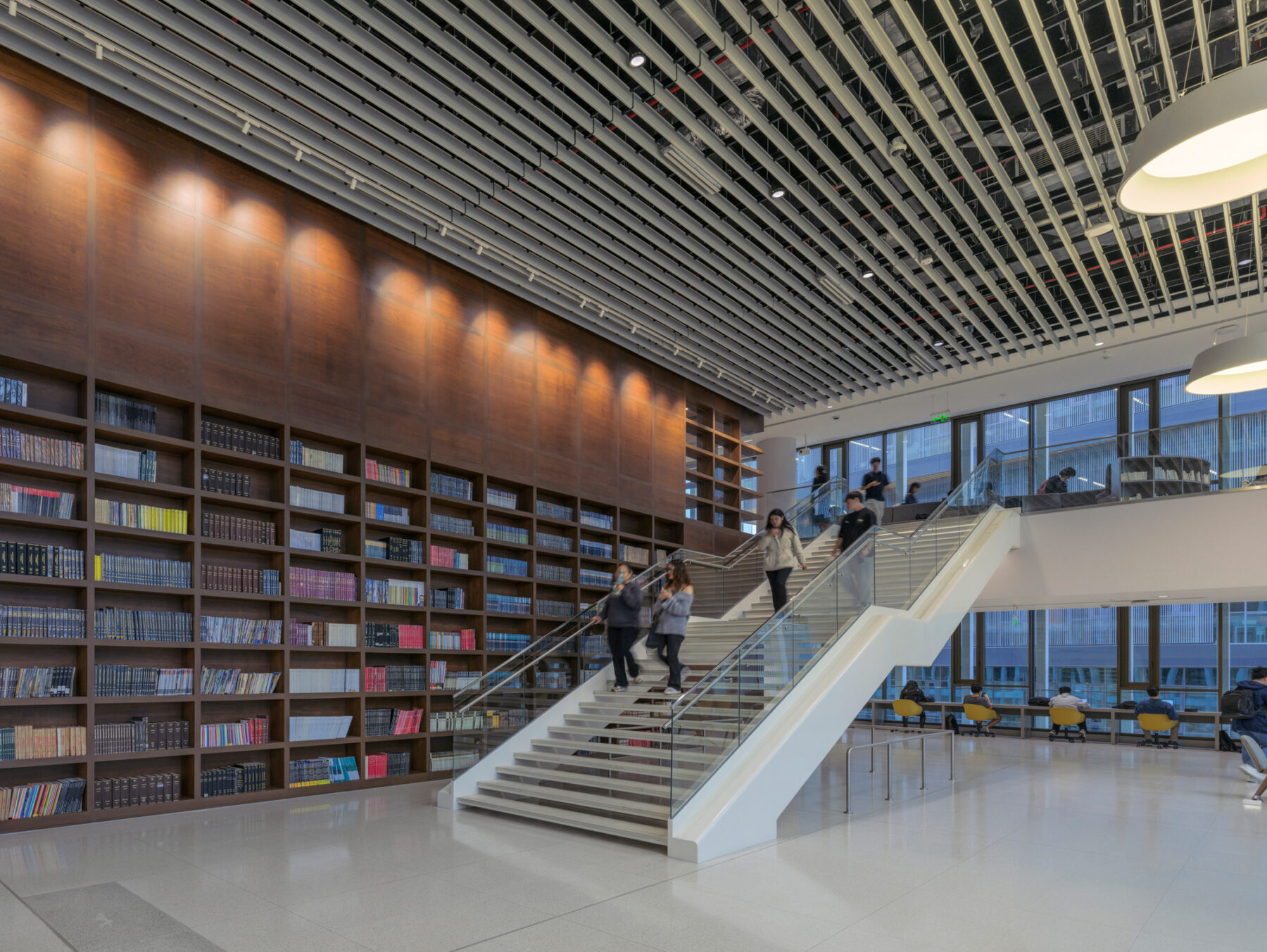 View of bookcase wall and stairs seen from lobby