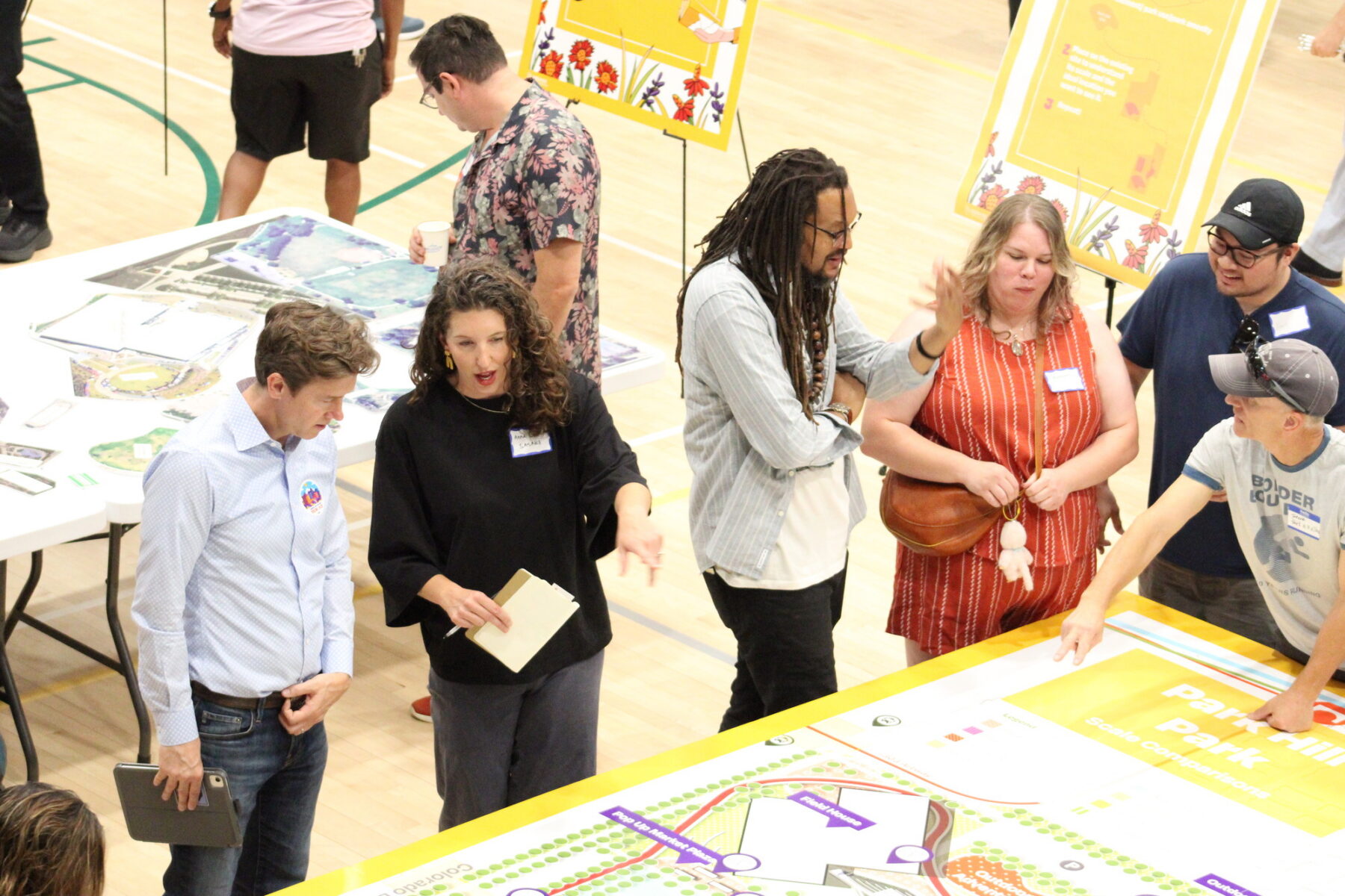 Photo of community engagement event with Sasaki Principal Anna Cawrse discussing large map with Denver Mayor