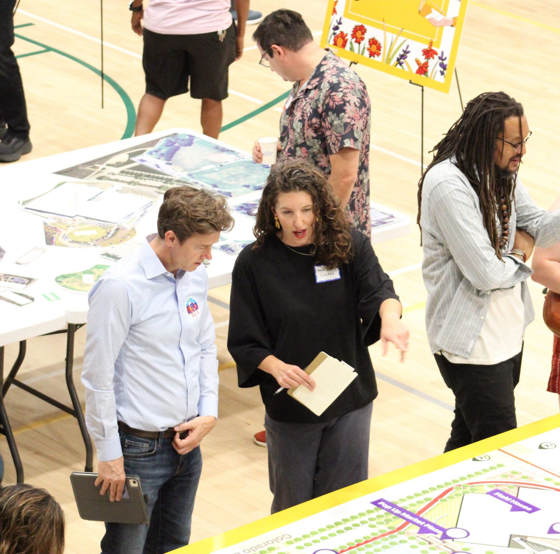 A group of people stand around a table at a community engagement event