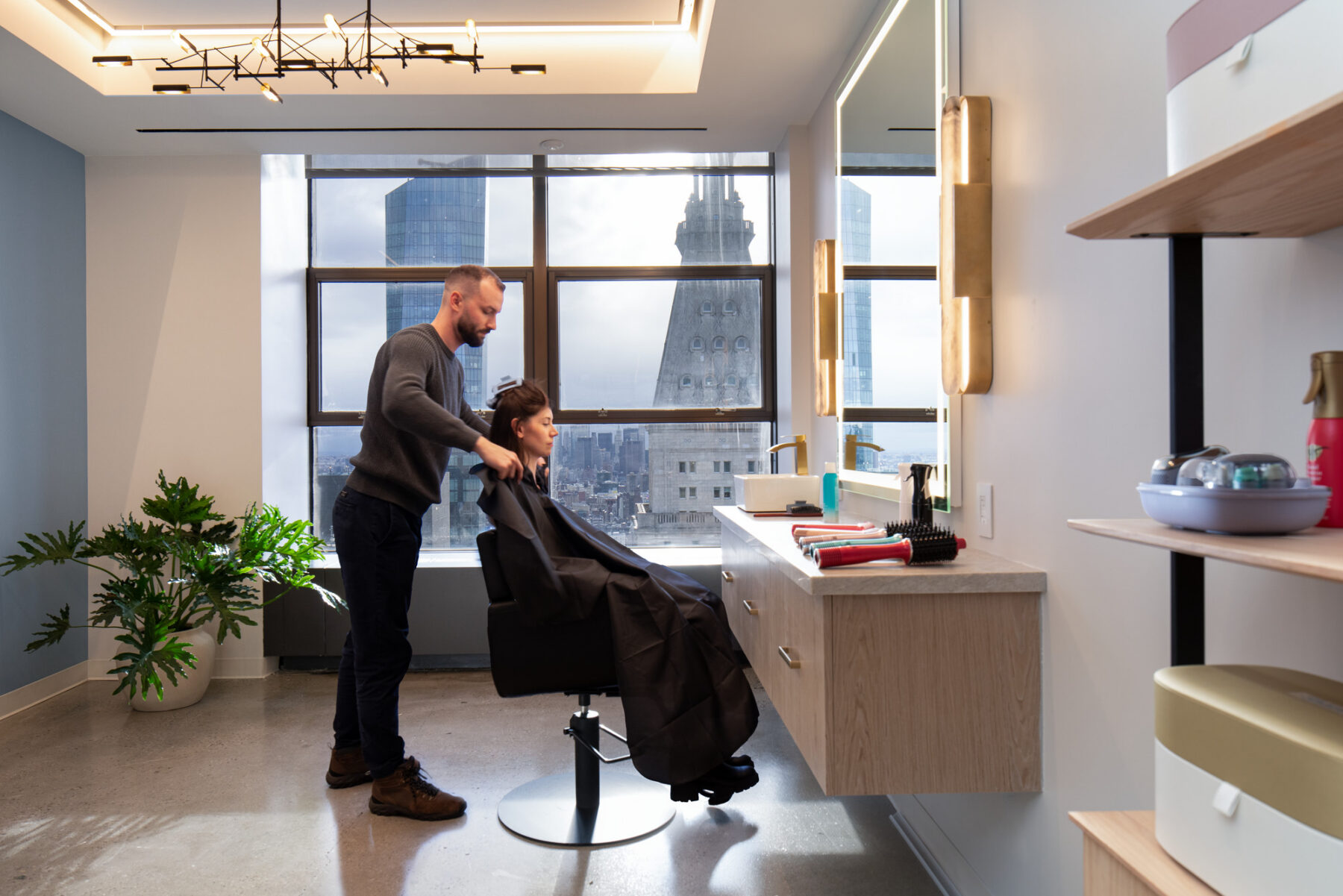 photograph of a beauty salon showing two people and views out to the city