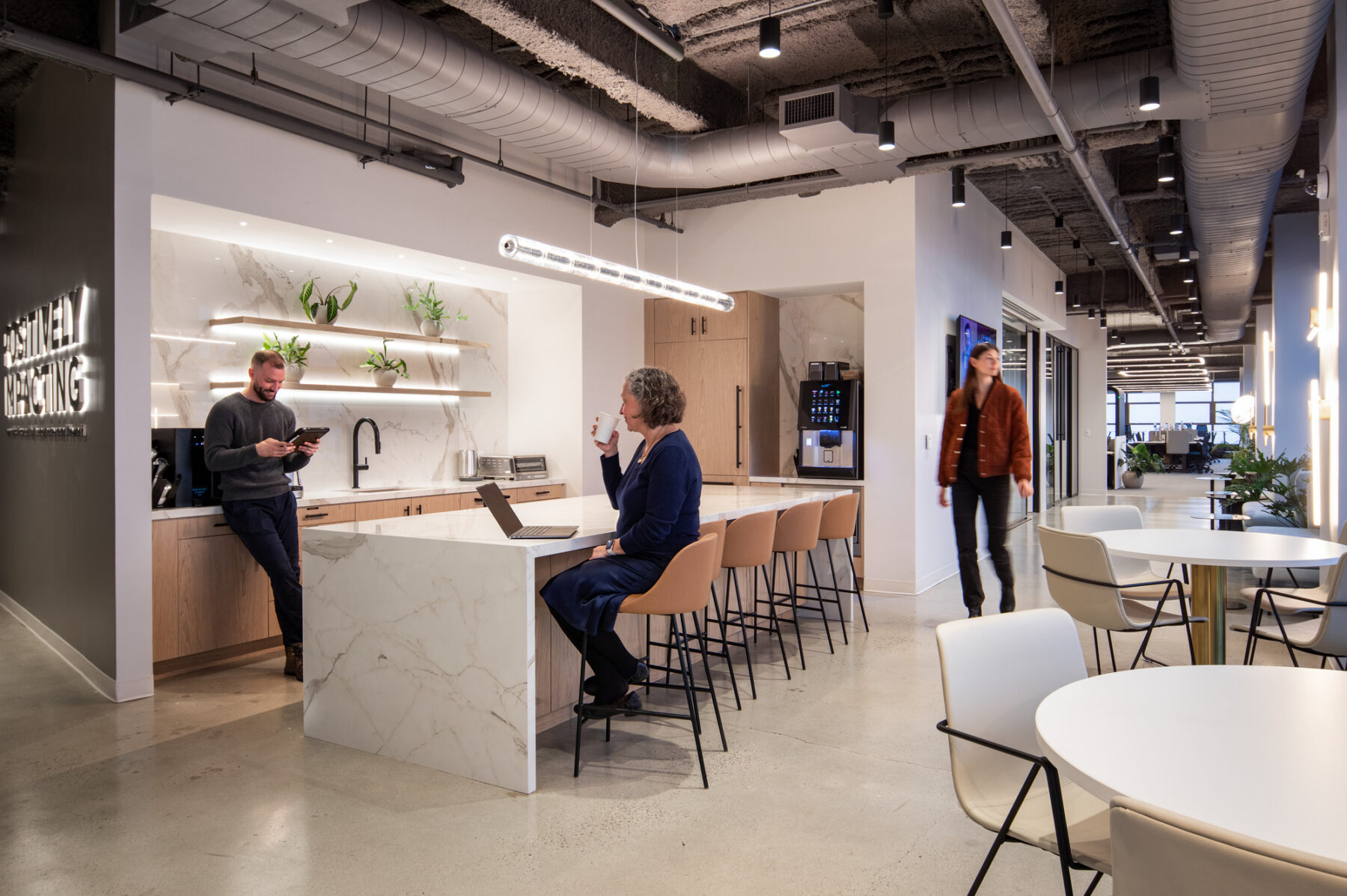photograph of a corporate setting kitchenette with three people gathering