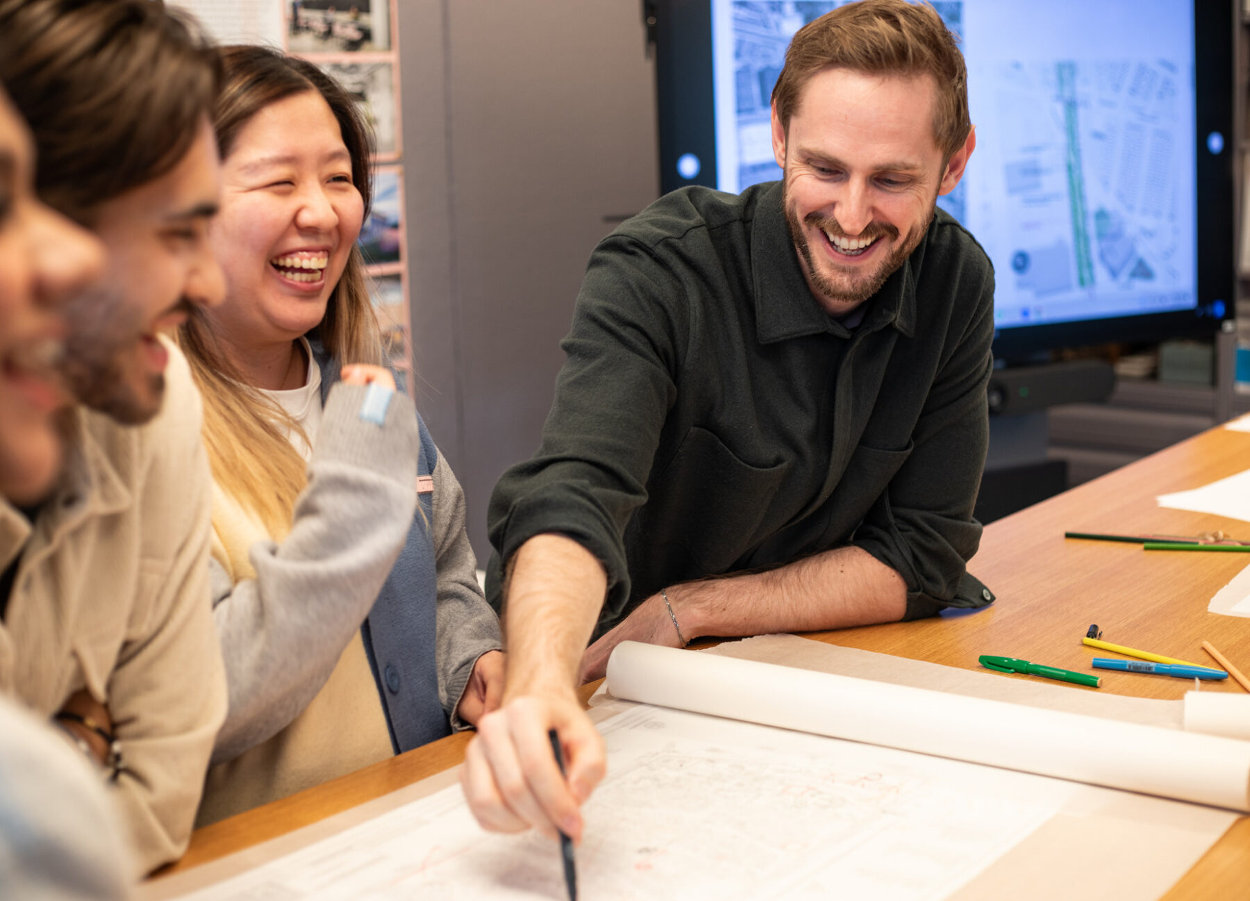 A group of people gathered around architectural drawings on a table