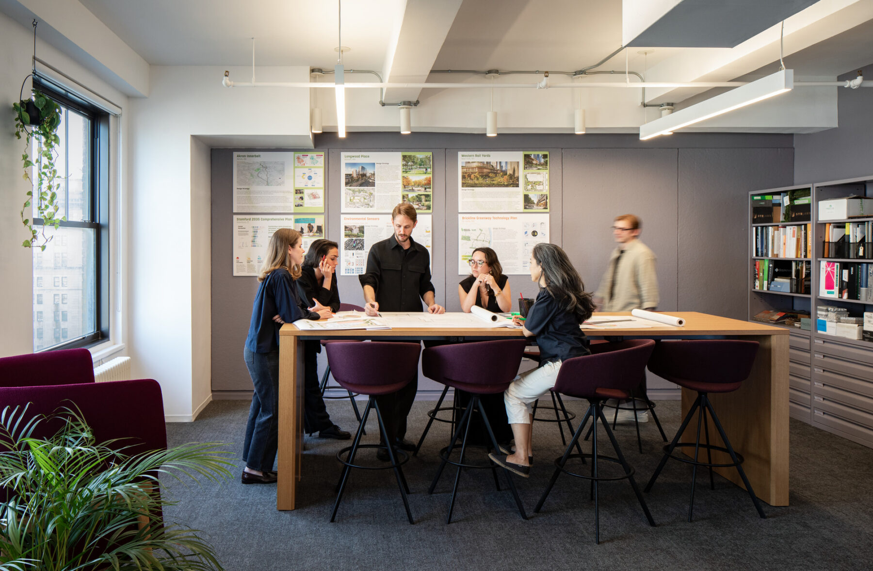 Photo of six people gathered around a high top table in an office