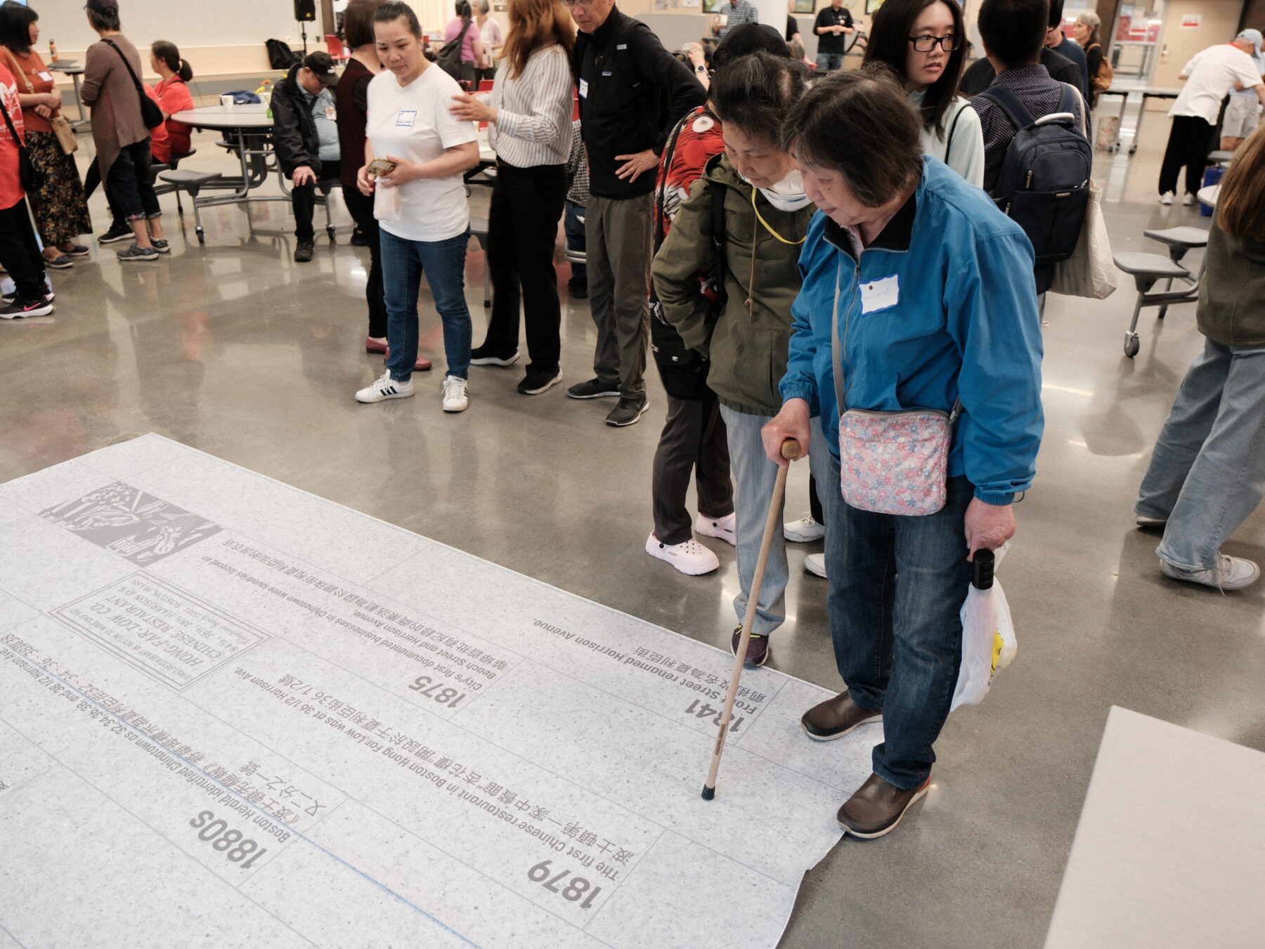 photo of two women standing and pointing to mock-up of pavement design
